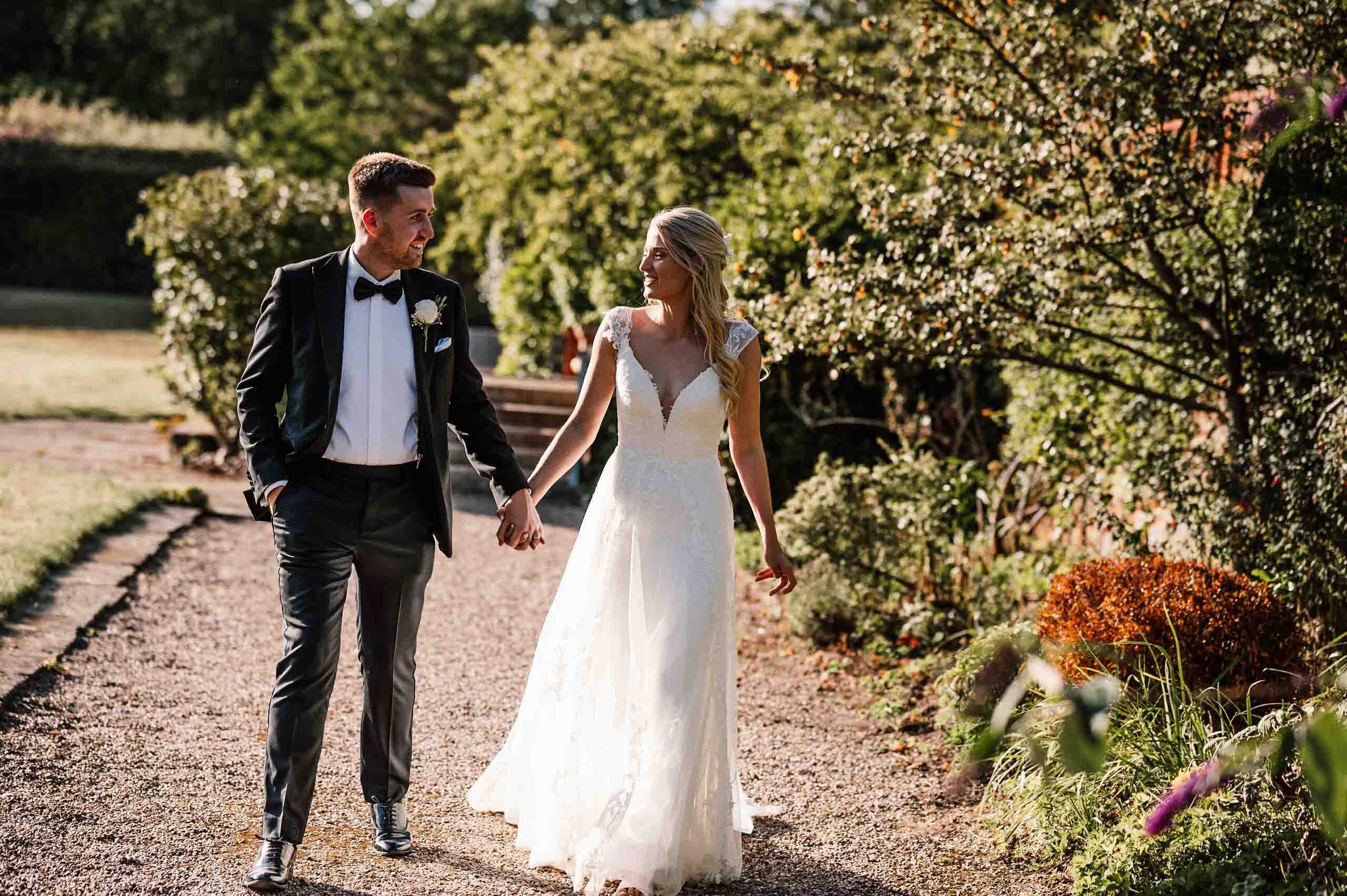 Bride and groom enjoying a walk in the grounds at Hodsock Priory on their wedding day