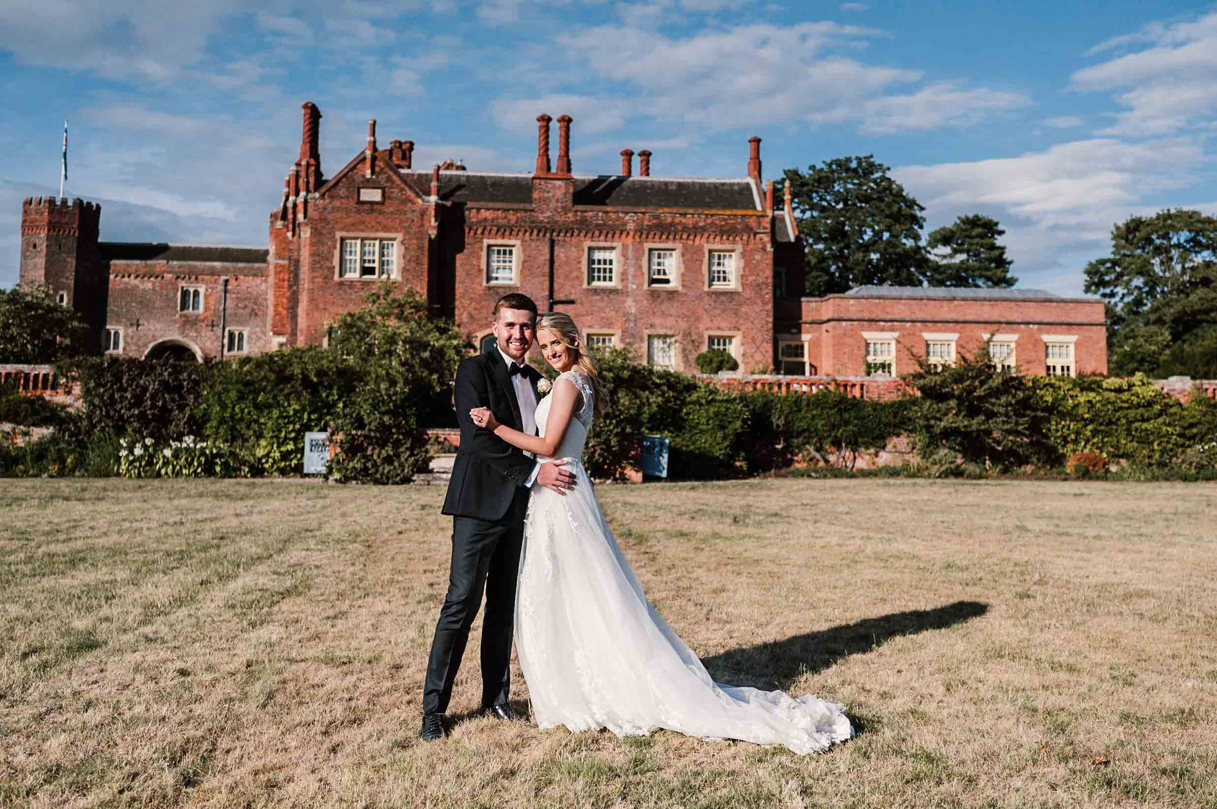 bride and grrom in front of the house at Hodsock Priory