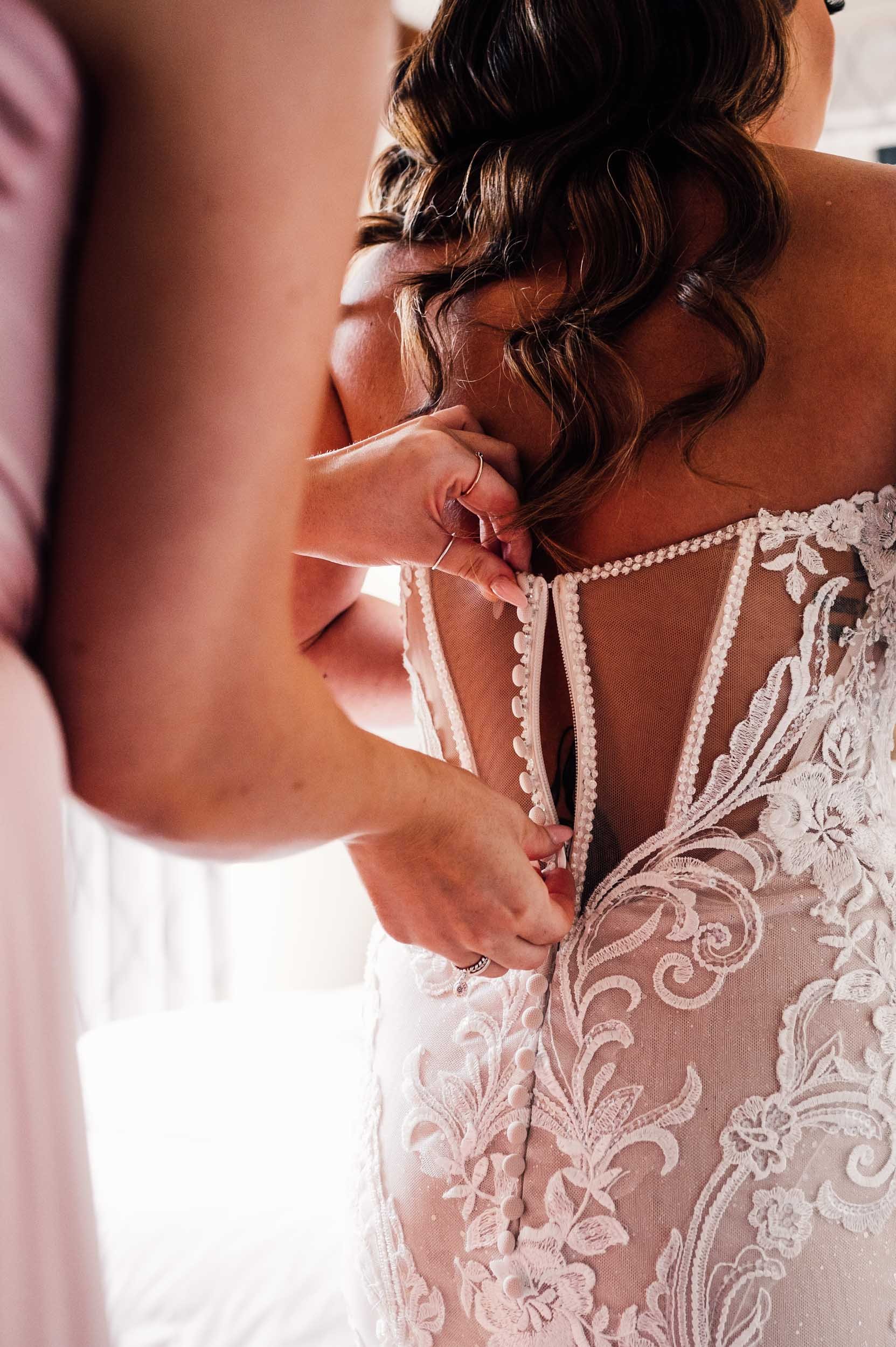 bride getting into her wedding dress