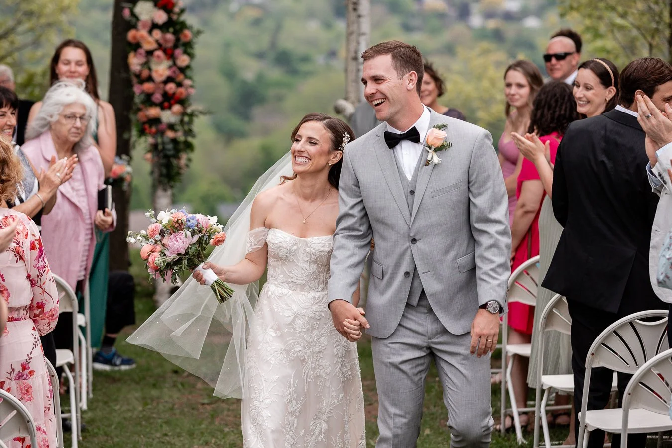 Happy newlywed couple smiles walking down the aisle in an amazing candid moment.jpg