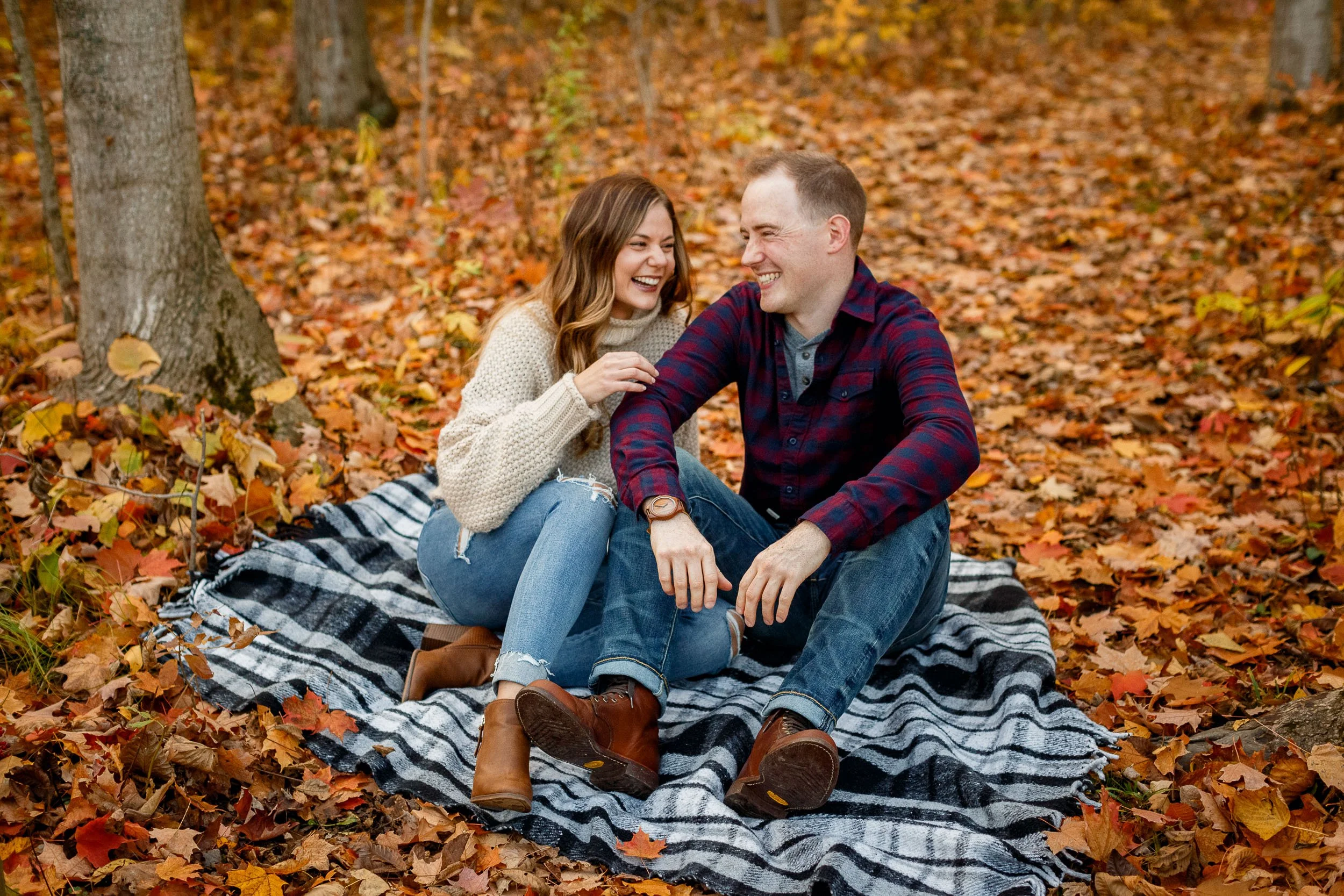Niagara Engaged couple share a casual laugh together in a fall engagement shoot in gorgeous fall Niagara Colours.jpg