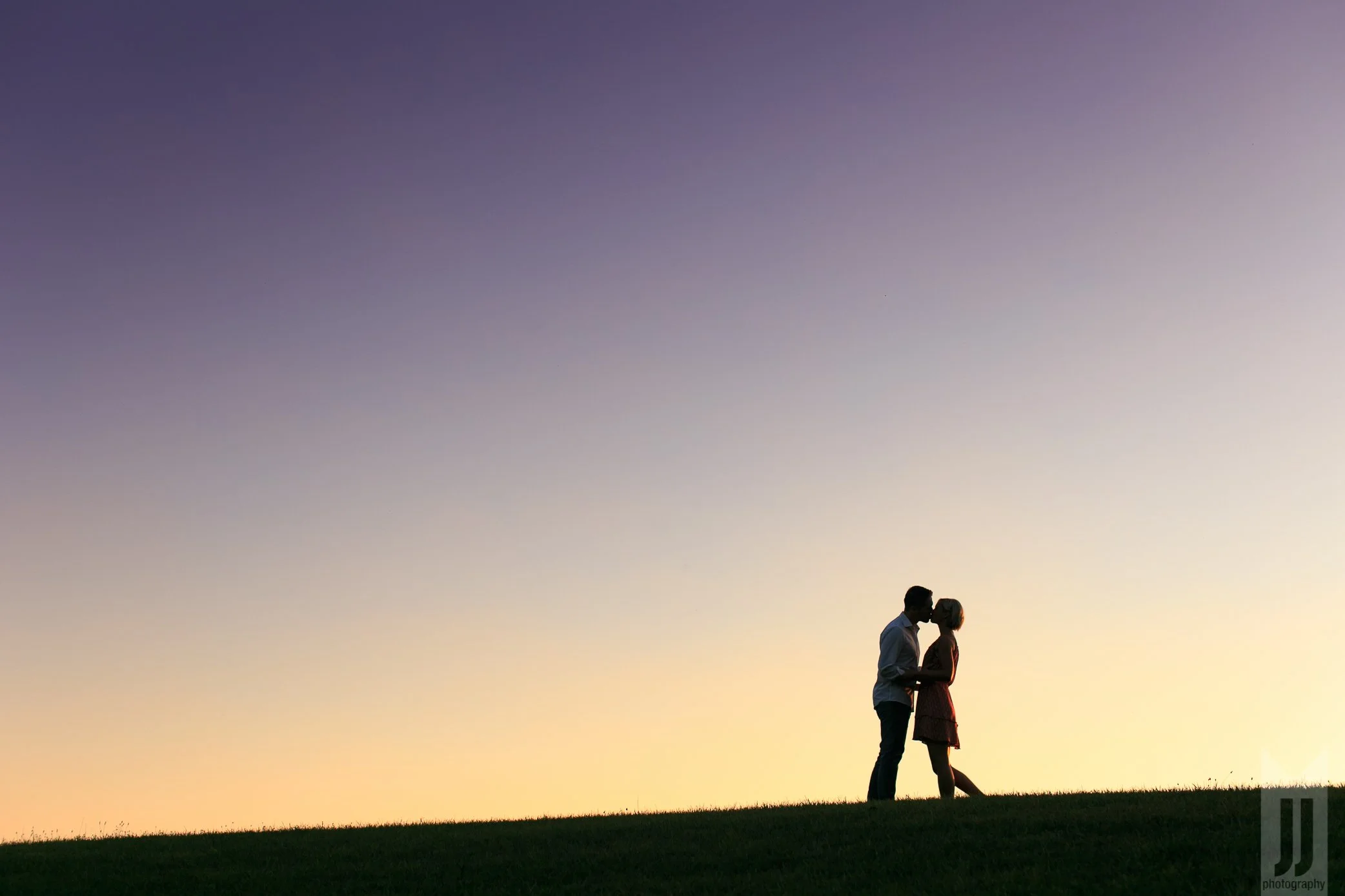 Niagara Photographer captures a couple kissing on a hill with a gorgeous gradient sunset as the backdrop.jpg