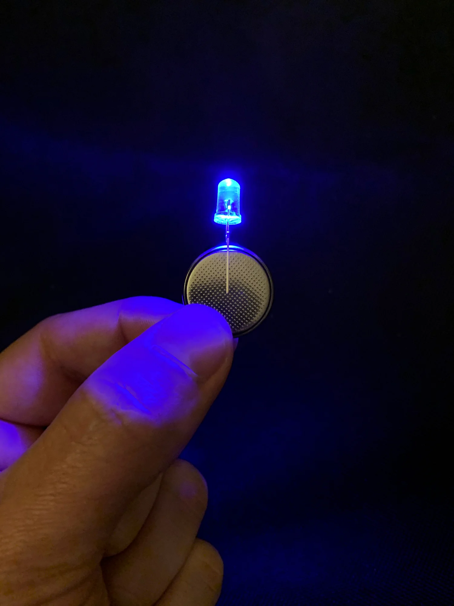 One of Alex’s blue LEDs attached to a 3V button cell