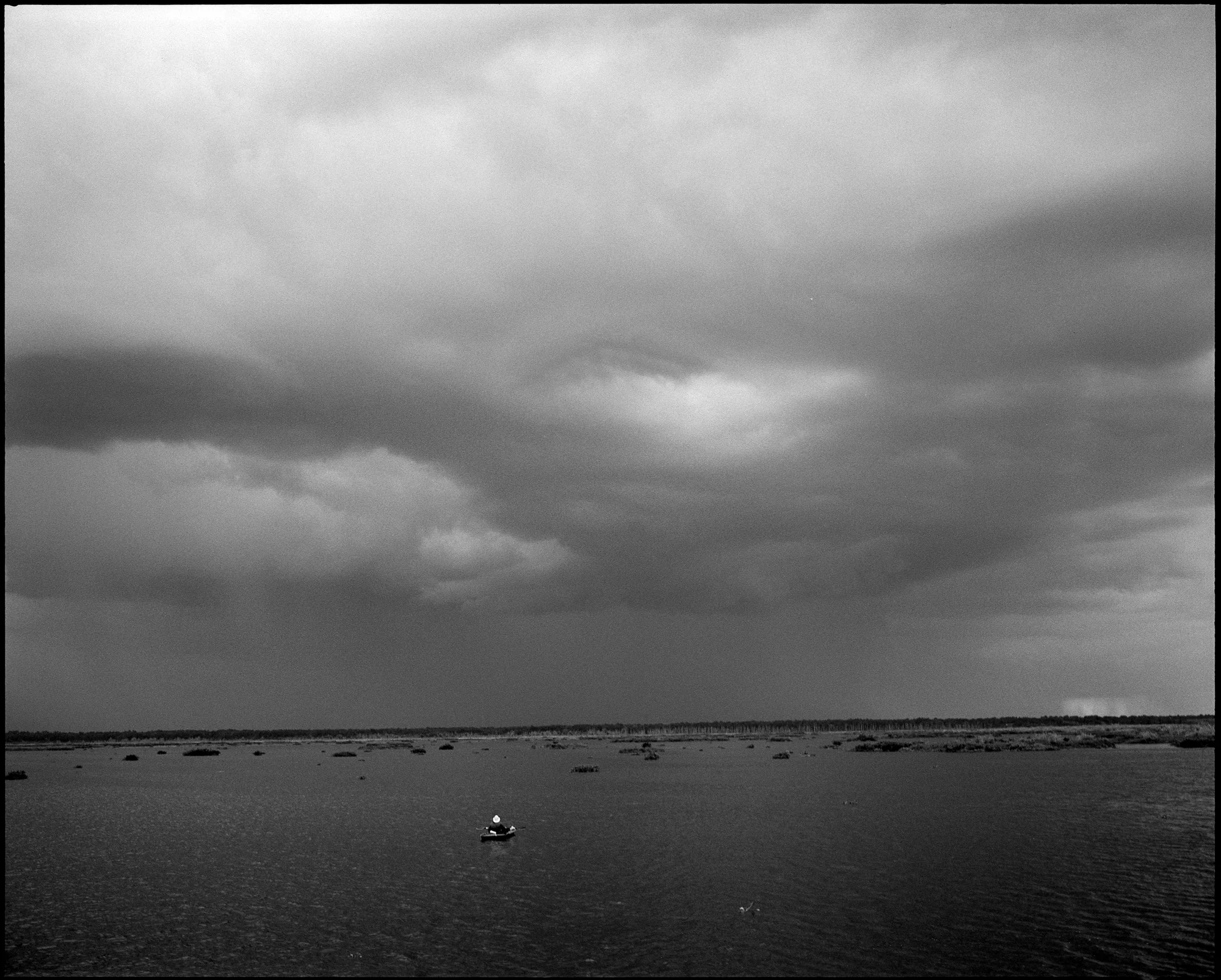 Alex sits in his kayak as a massive thunderstorm sweeps across Paynes Prairie Preserve.