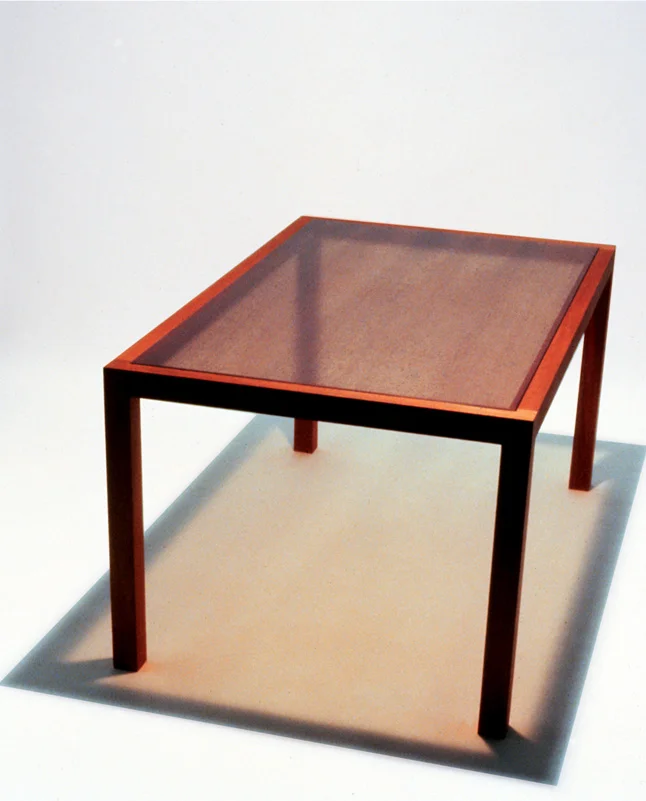   Utsurio Dining Table   Mahogany + Glass + Photographic Film 30”H X 40”W X 60”L  The glass top has an enlarged image of mahogany wood grain printed on graphic film that is permanently adhered to its underside. 
