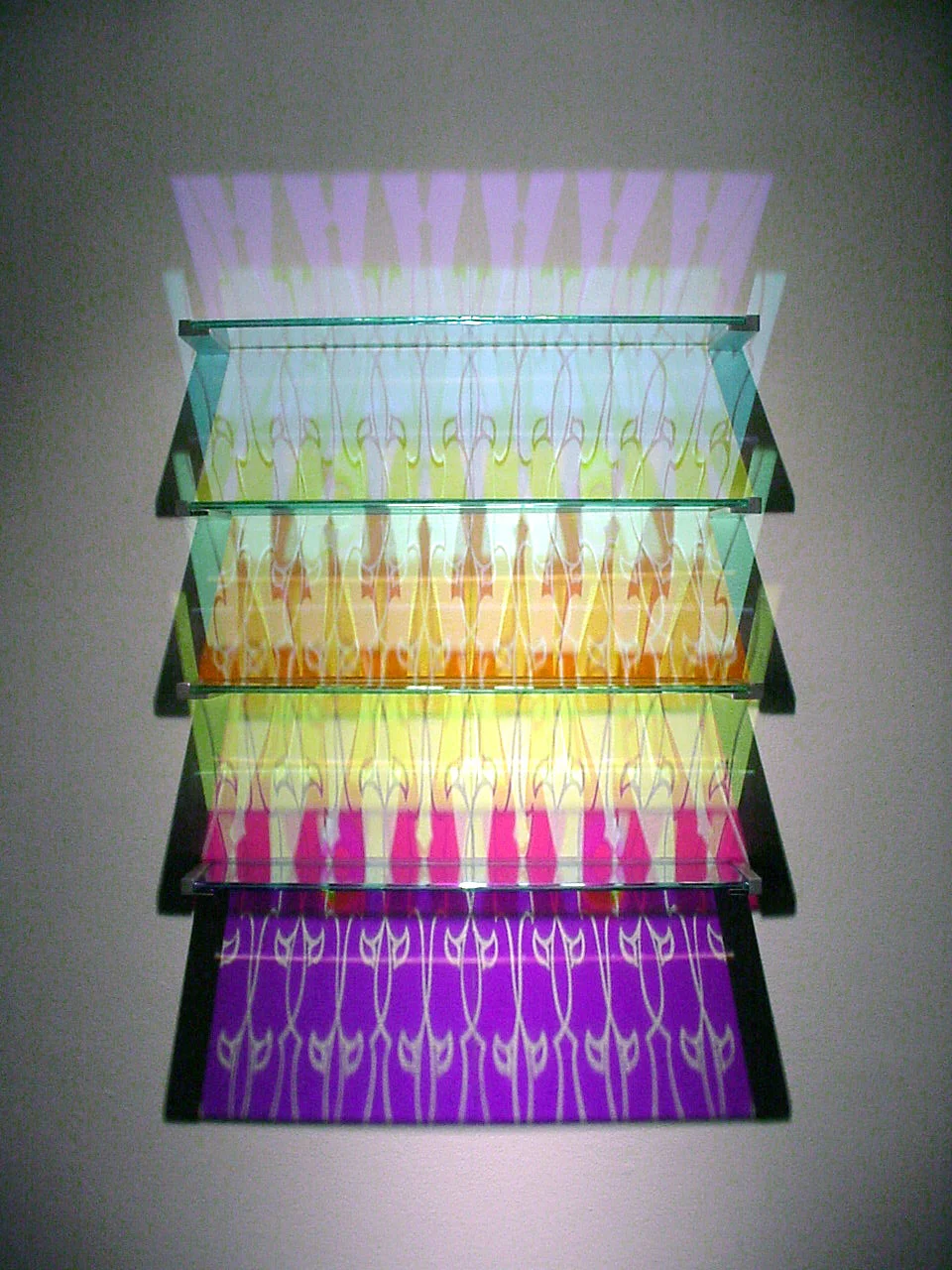   Aurora Shelving - Sullivan Pattern   Etched + Laminated Glass + Steel Wall Supports Various Dimensions  Glass shelving that   literally  paints  the wall with colored reflections when illuminated by a spotlight from above. There are no visible colo