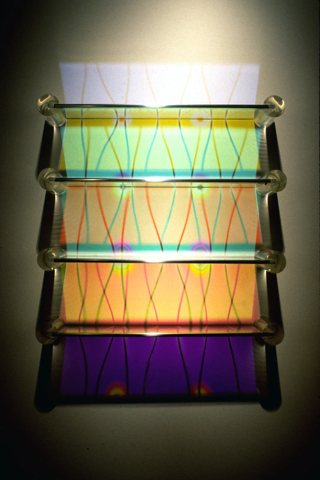   Aurora Shelving - Wave Pattern   Etched + Laminated Glass + Steel/Acrylic Supports Various Dimensions  Glass shelving that   literally  paints  the wall with colored reflections when illuminated by a spotlight from above. There are no visible color