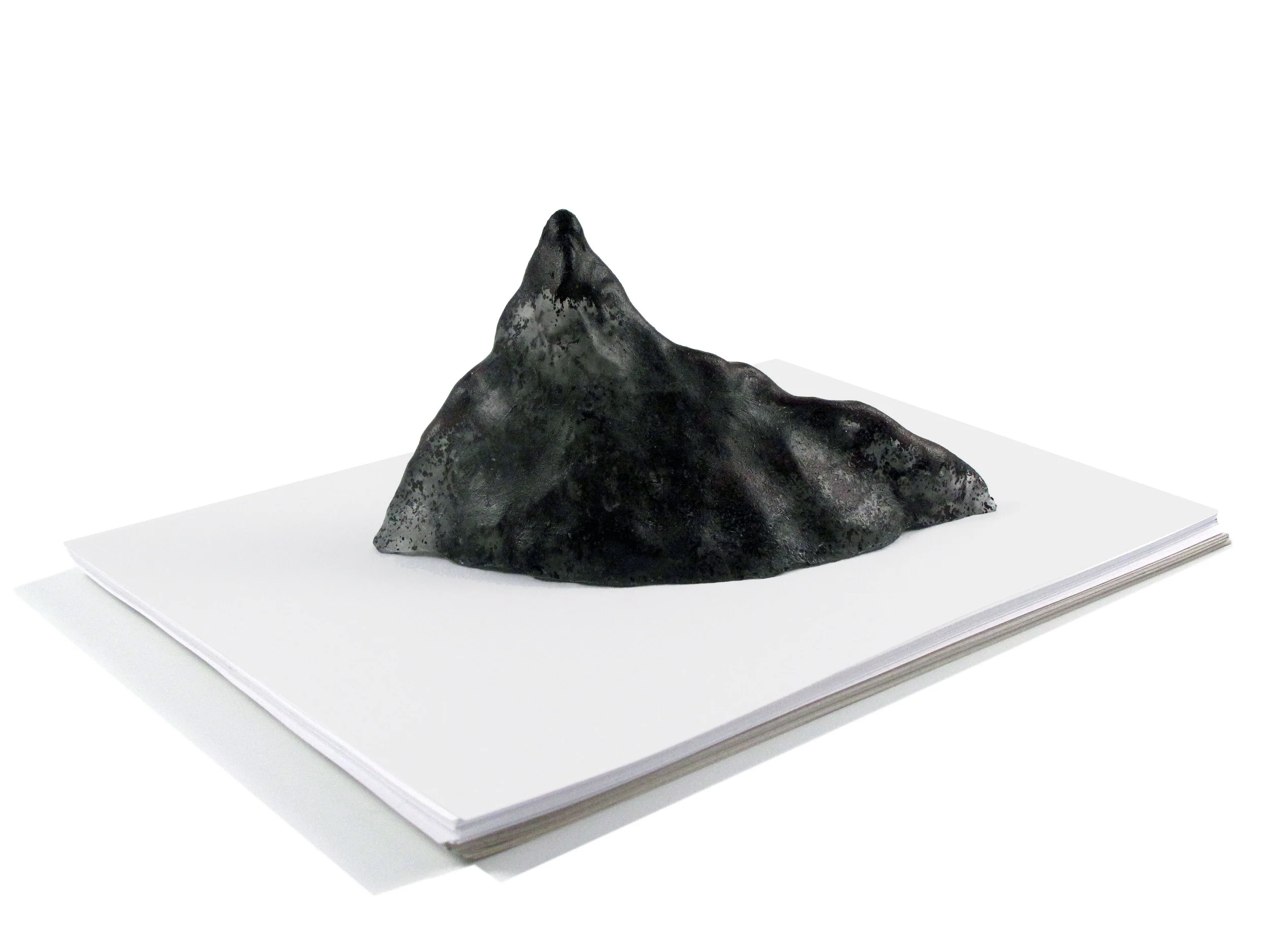   Munro Series - Volcano  Paperweight  Cast glass 8” L X 4” H X 3.5” D  Only one cast is made from each hand modeled clay form, making every Munro in the series unique. 