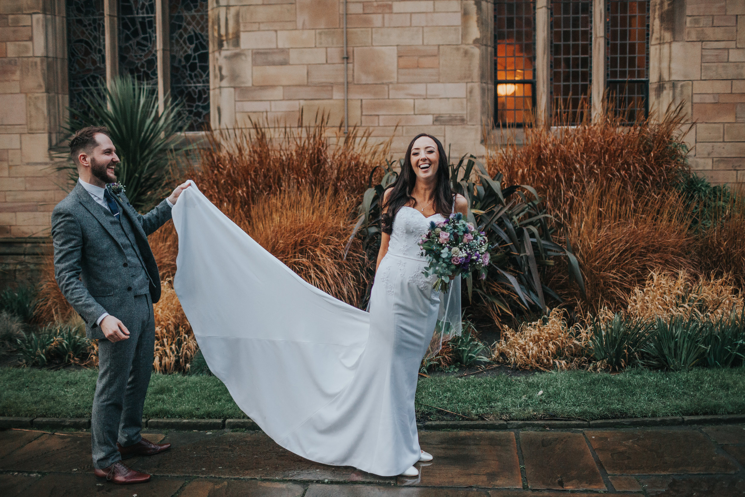 Bride laughs as groom fixes dress