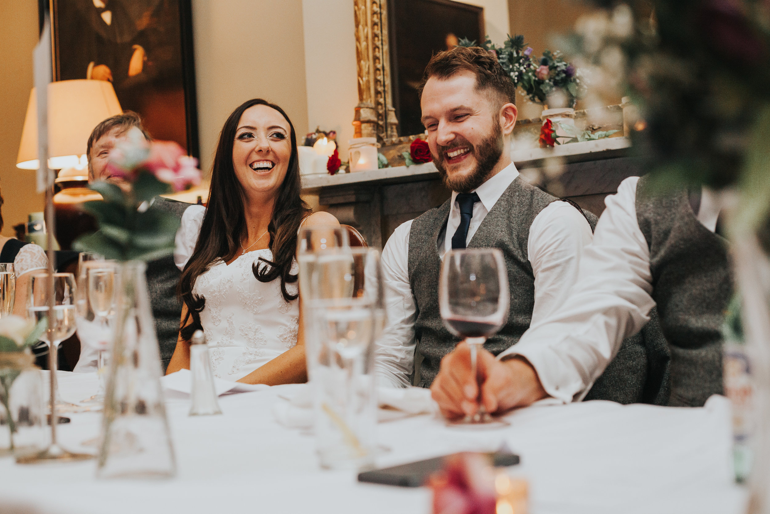 Bride and Groom laughing at Speeches