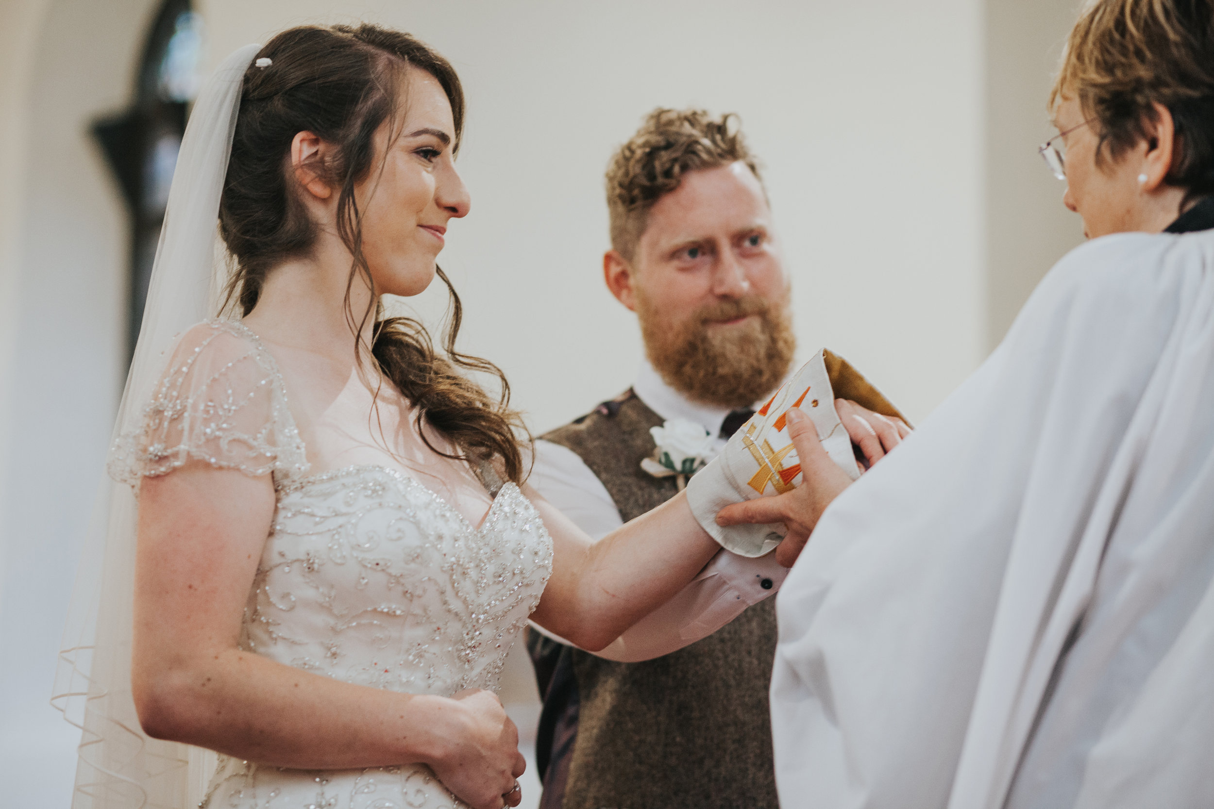  Vicar wraps couples hands in fabric.&nbsp; 