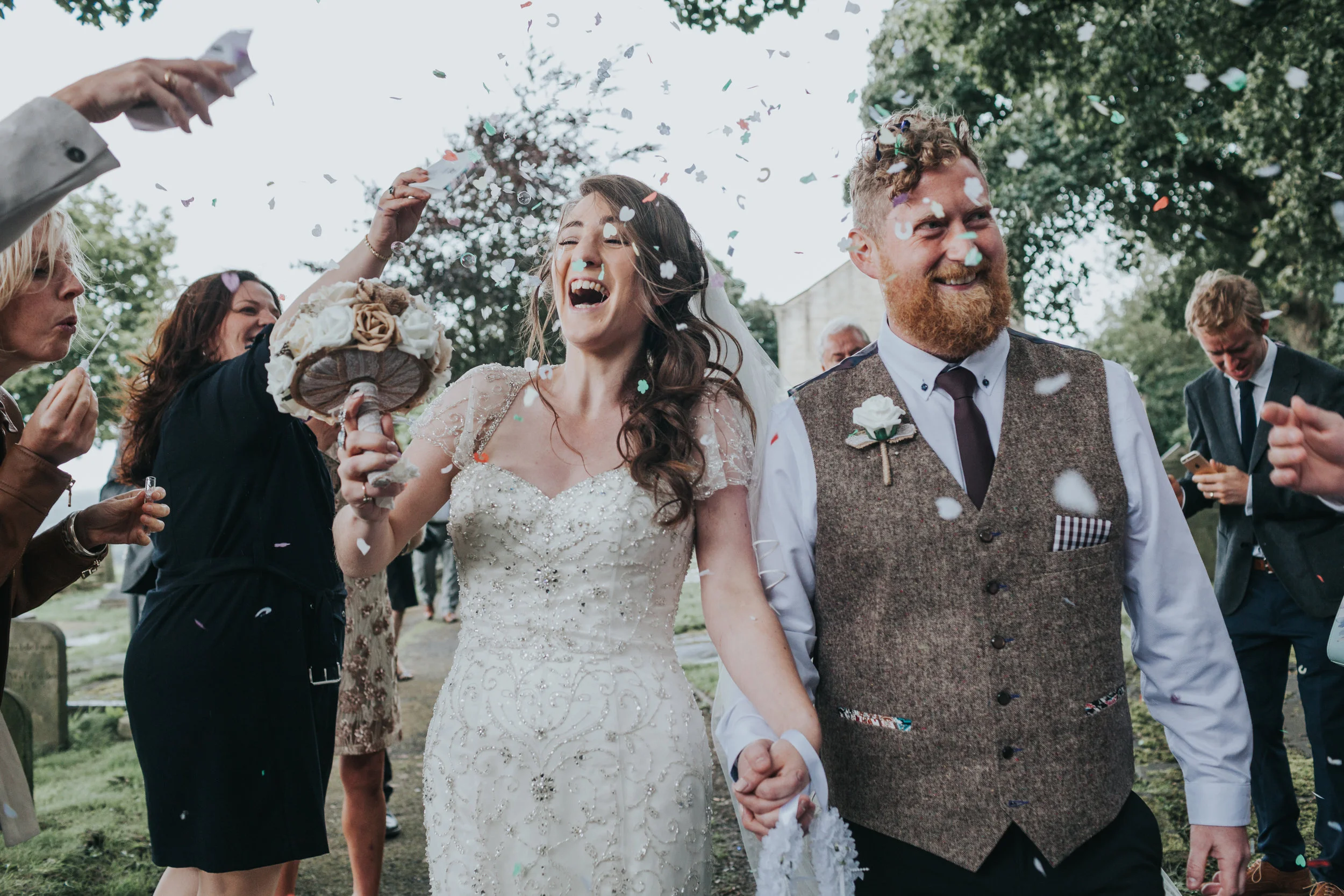 Newly weds still being attacked with confetti.