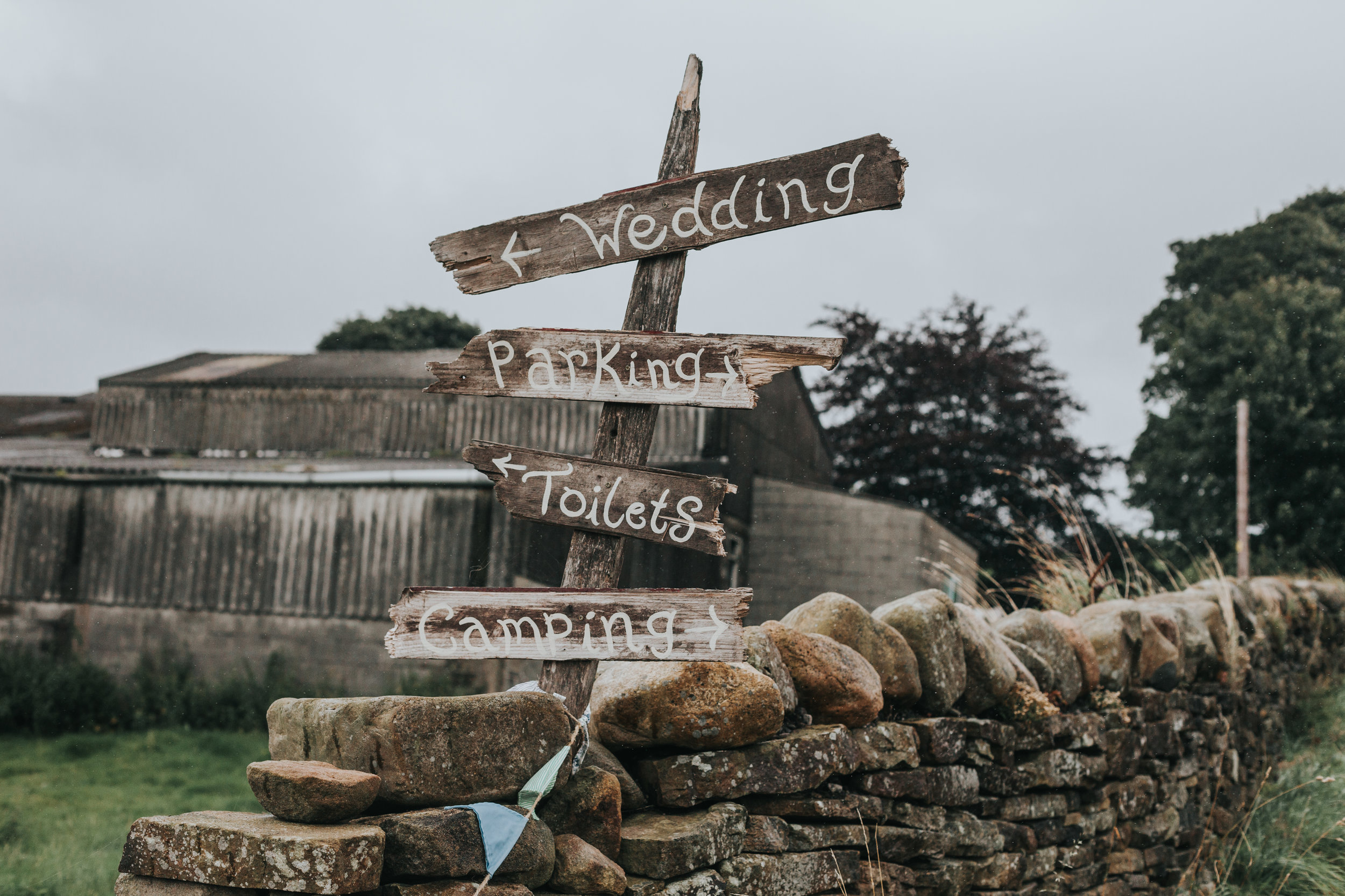  Hand made signs on wood reading WEDDING, PARKING, TOILETS AND CAMPING.&nbsp; 