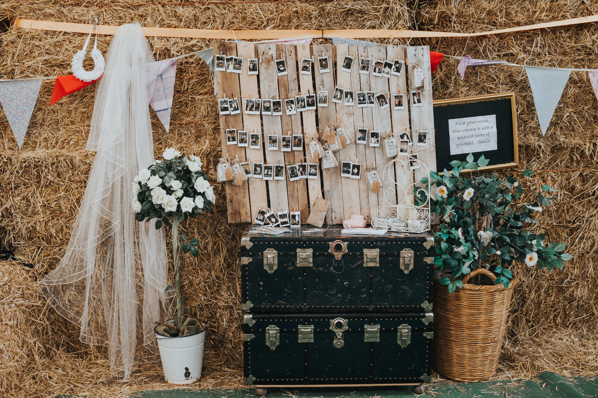  Polaroid photo wall, veil, horse shoe and flowers on hay stack wall. 