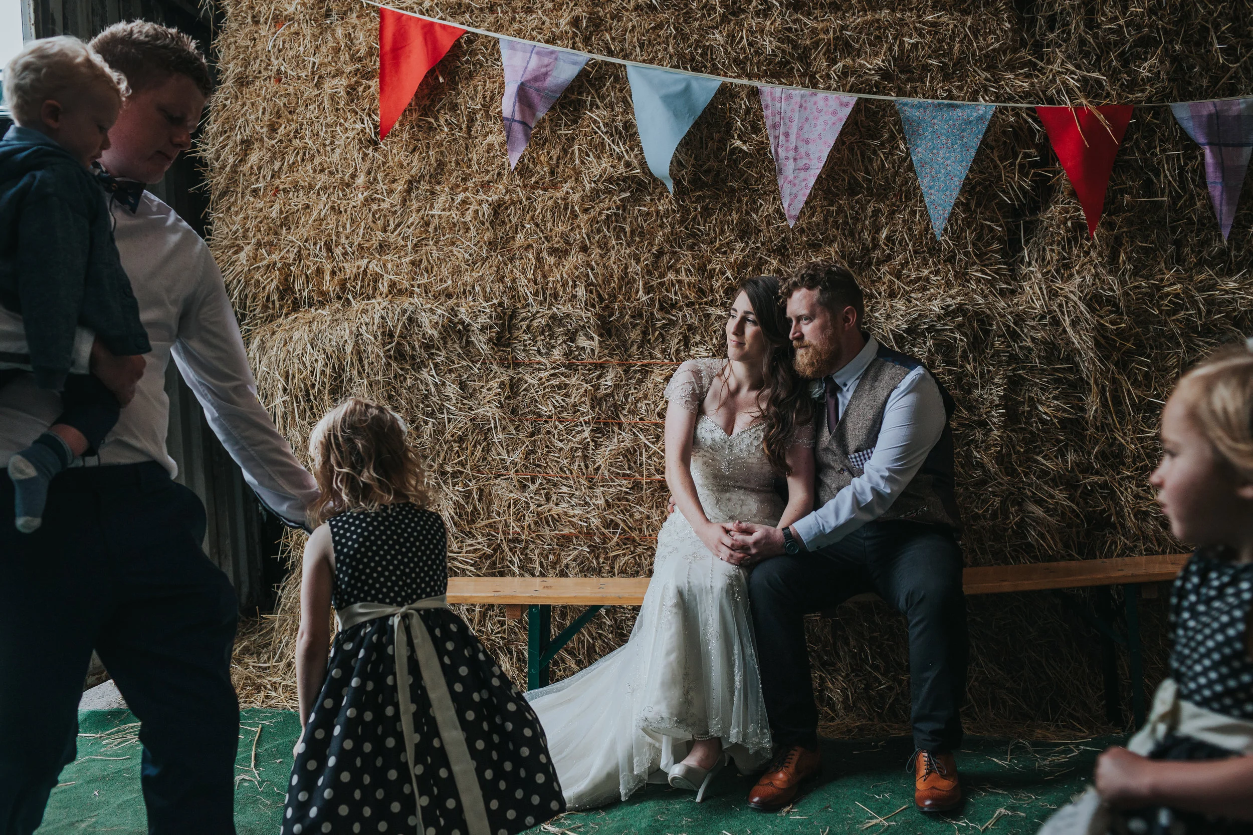  Bride and Groom take a moment together while children tear past.&nbsp; 