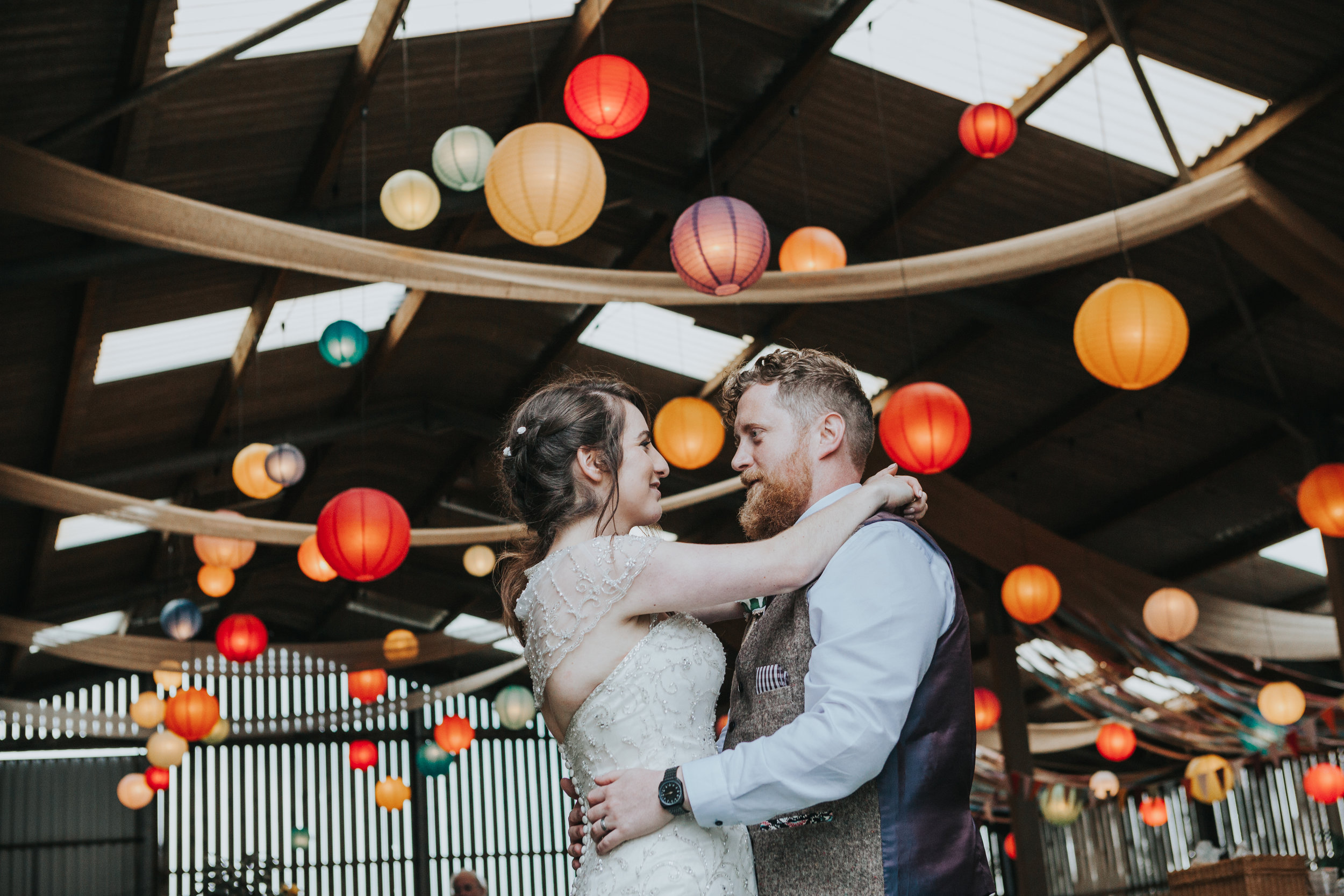  Rachel and Matthew stand together in front of room full of colourful lanterns  
