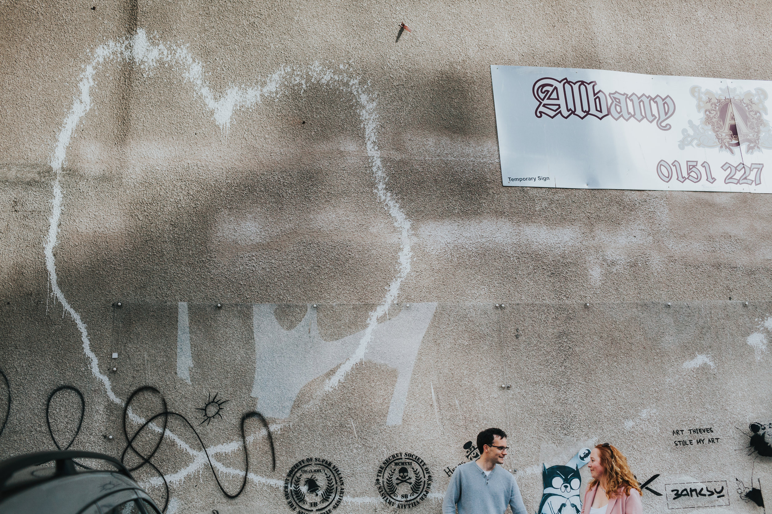 Couple in front of Banksy heart Liverpool