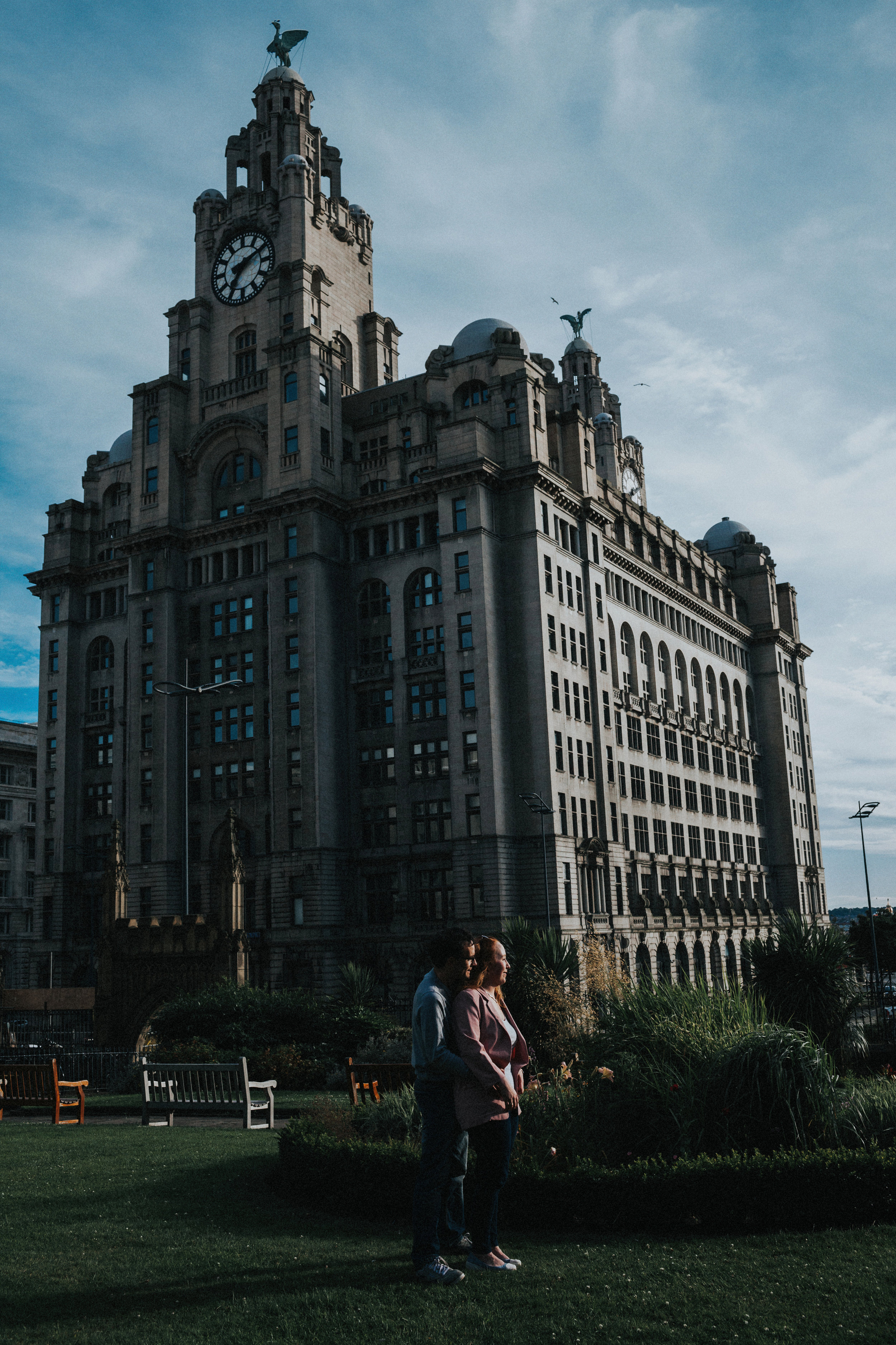 Sun hits couple in front of Liver Buildings 