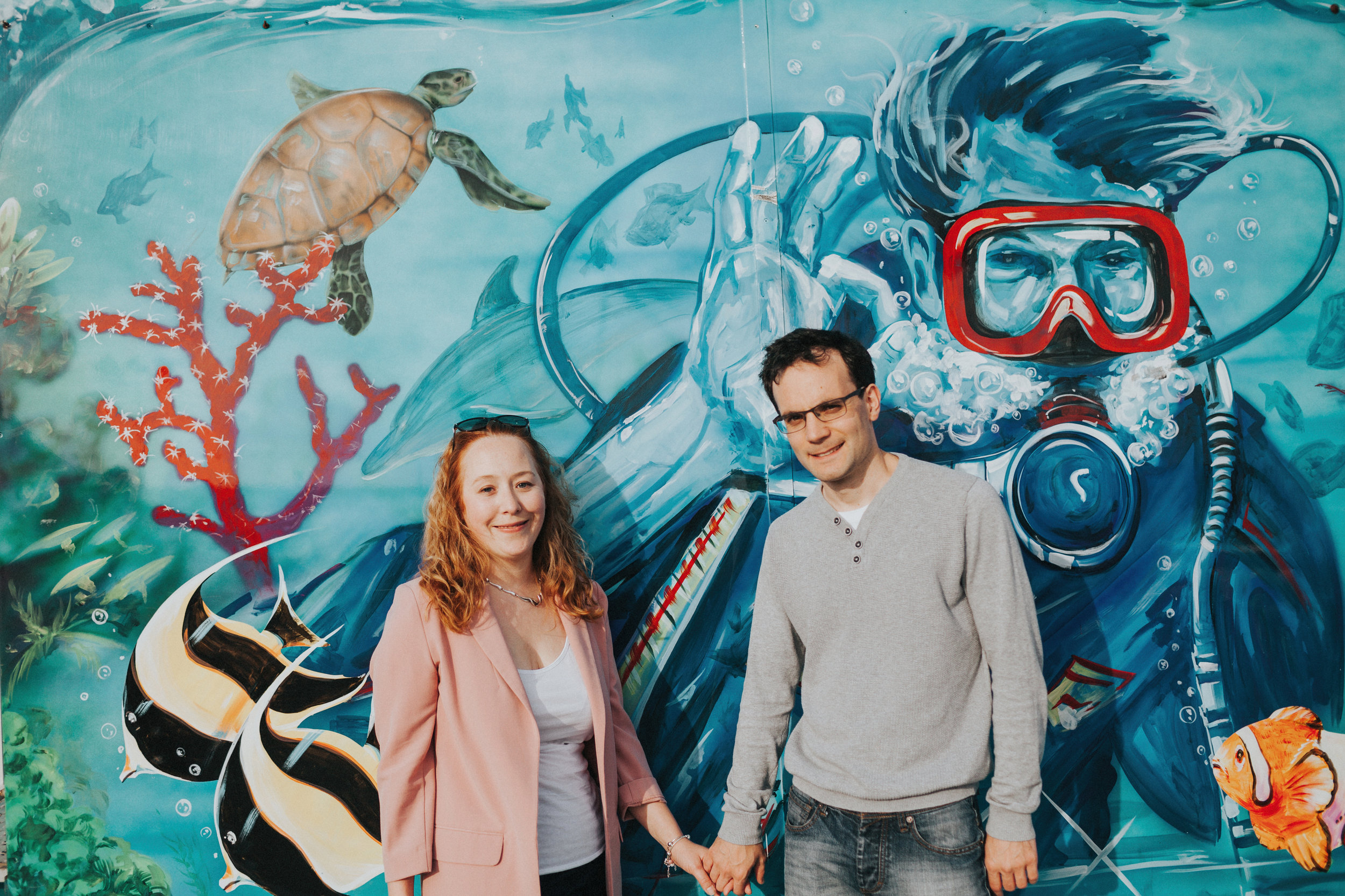 Couple in front of mural of divers in the River Mersey?