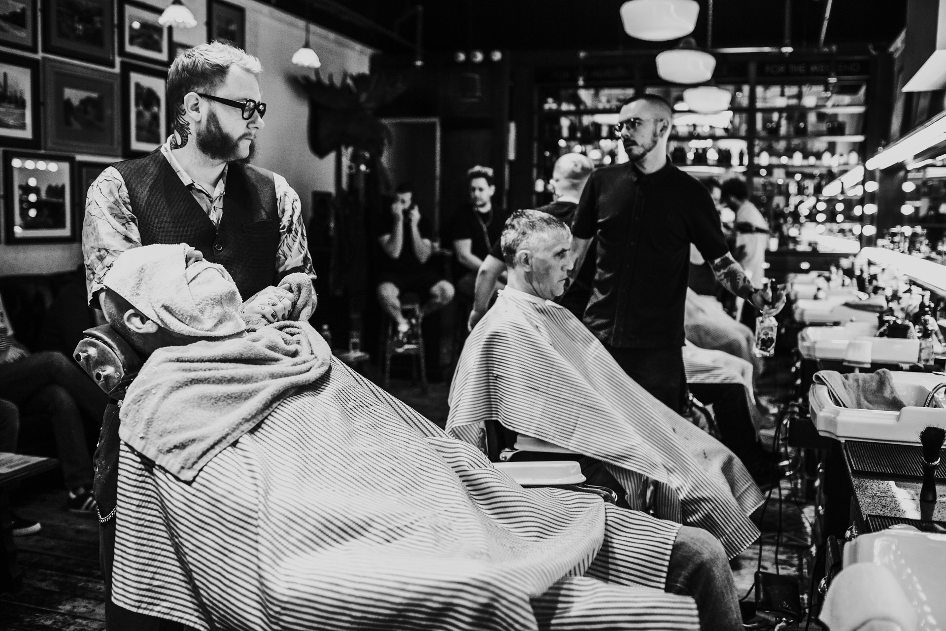 Grooms men getting cut throat shaves in Manchester wedding documentary style photographs