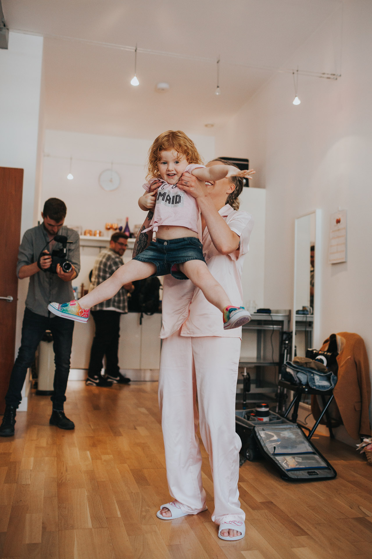 Bride lifts flower girl up in the air
