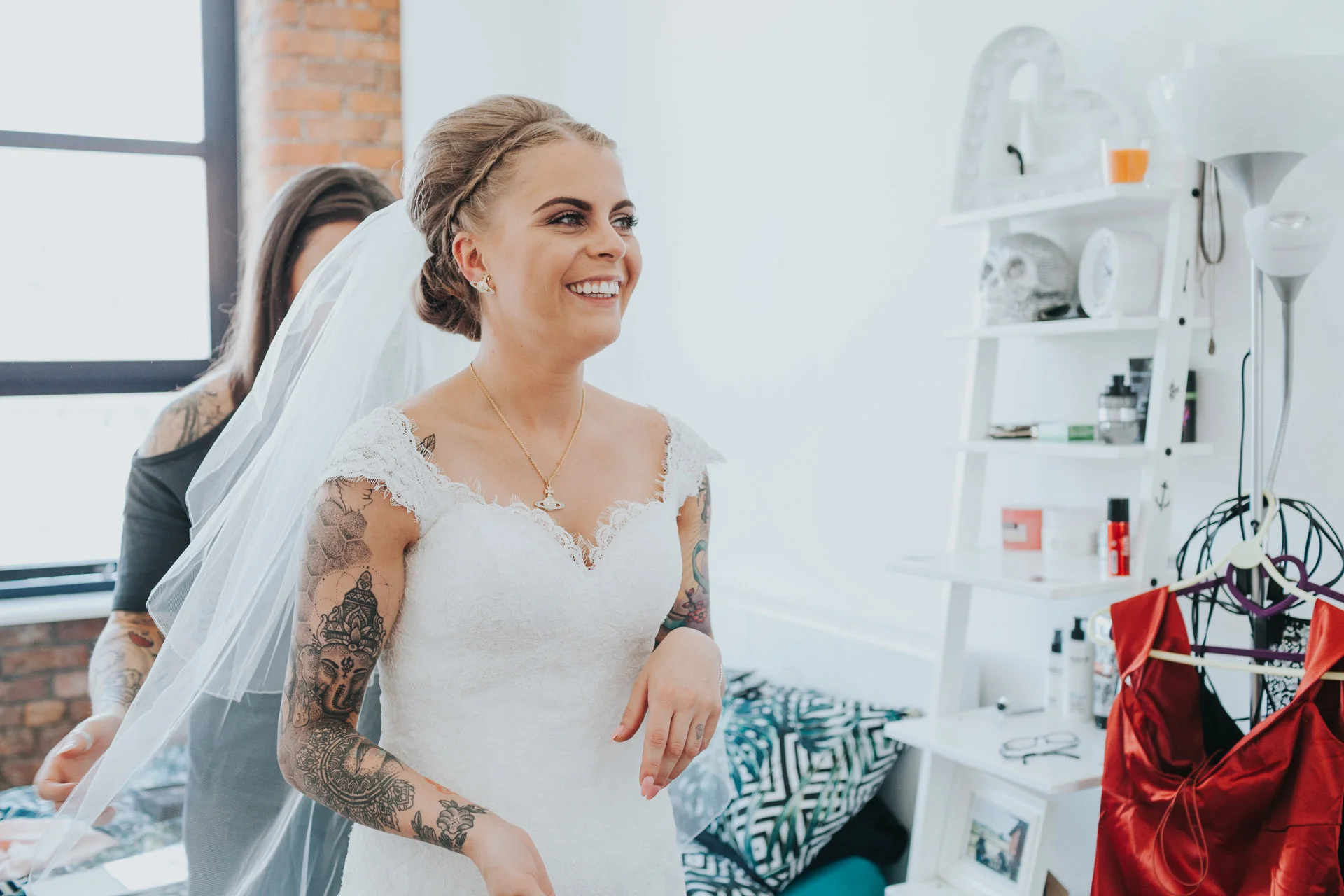 Smiling excited Bride has her veil put on.