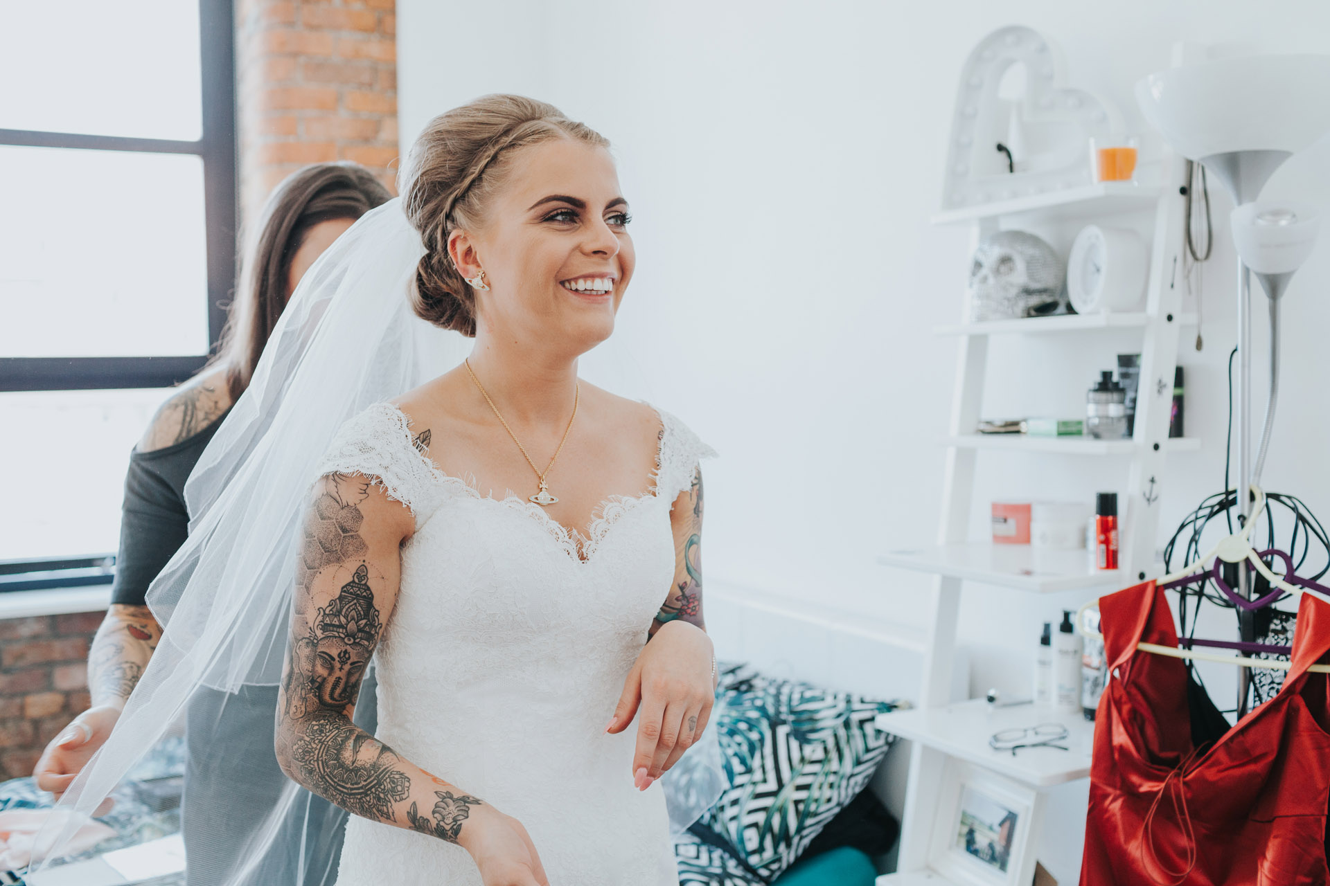 Smiling excited Bride has her veil put on.