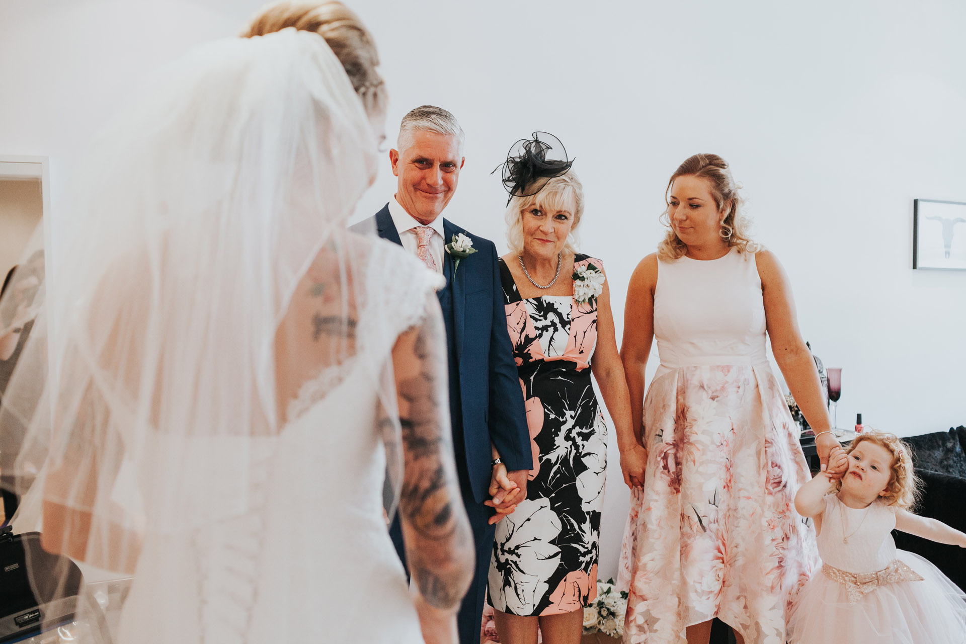 Bride comes out to see her family in her wedding dress.