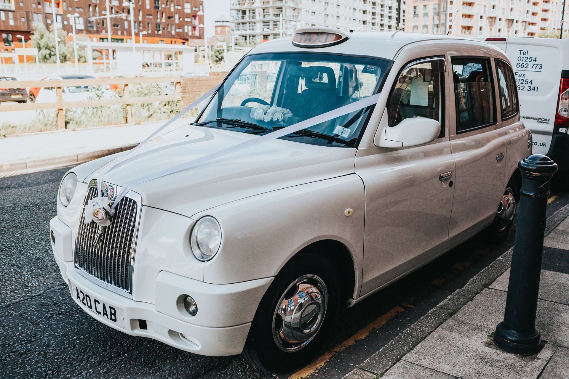 White taxi awaits bridal party.