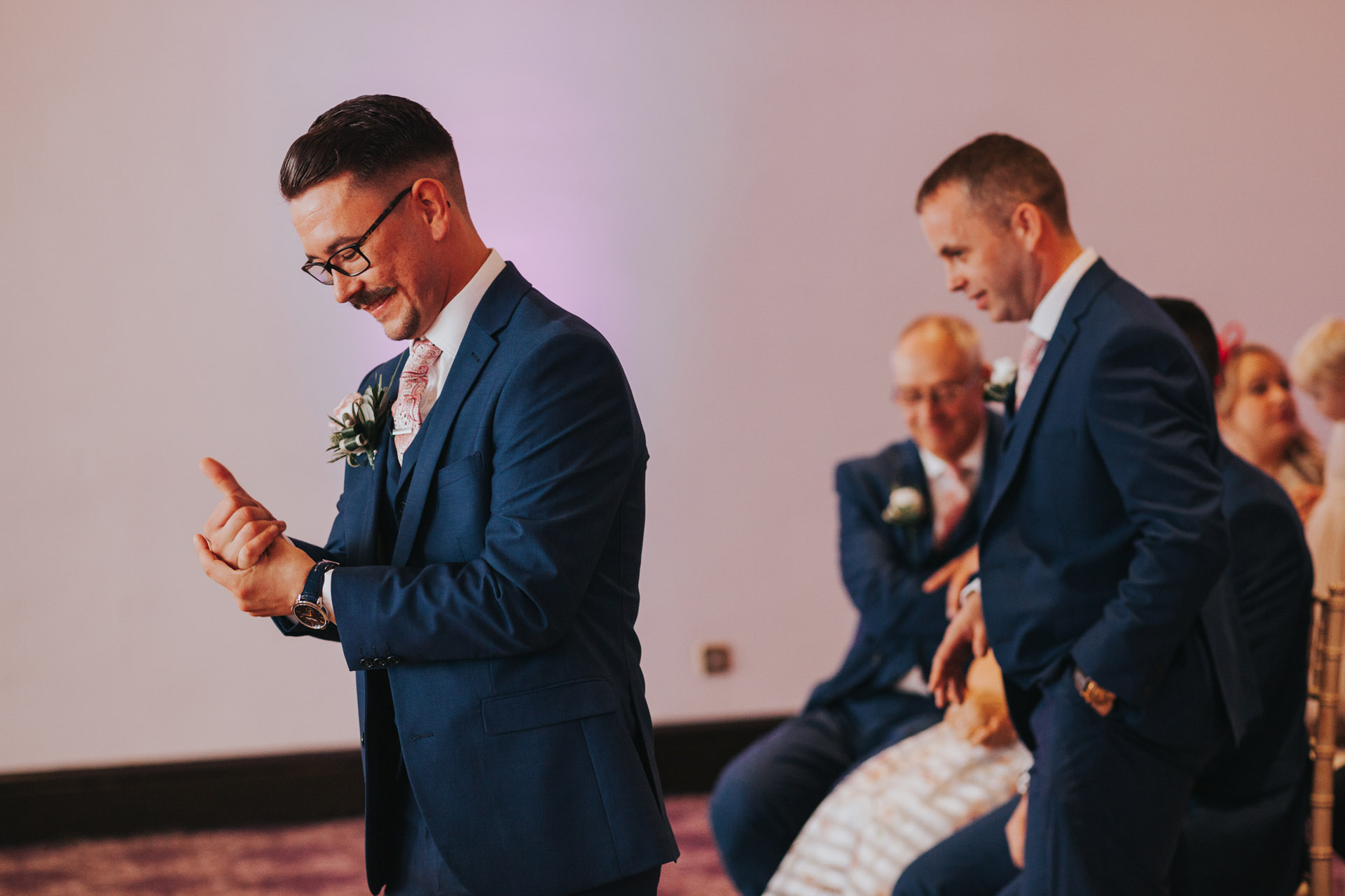 Groom stands alone.