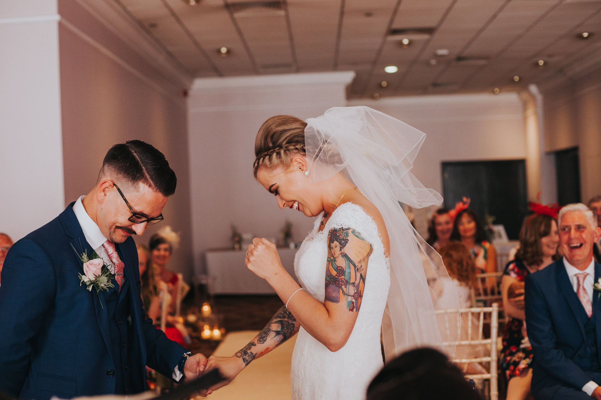 Bride and groom laugh together during ceremony. 