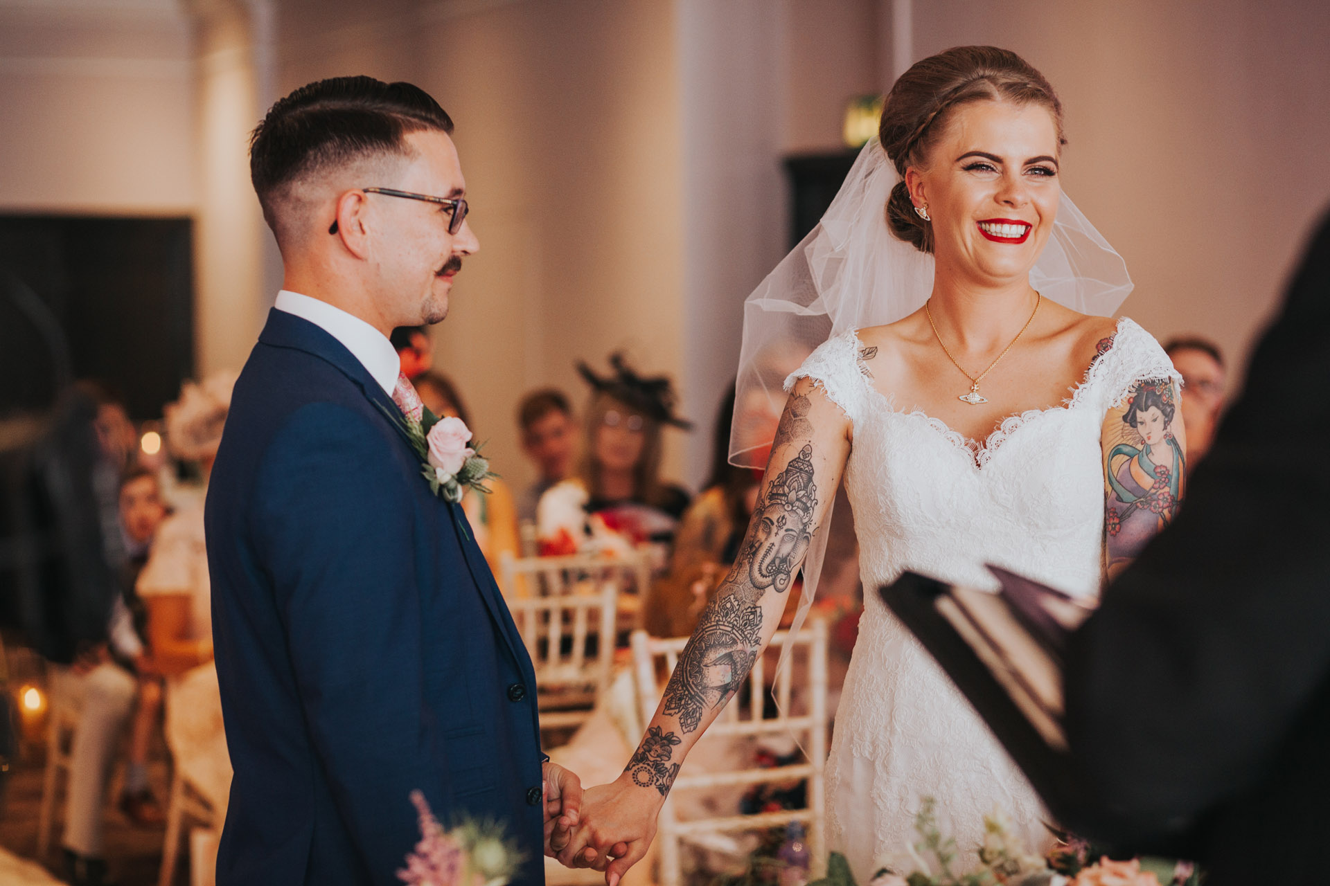 Bride looks at registrar excitedly.