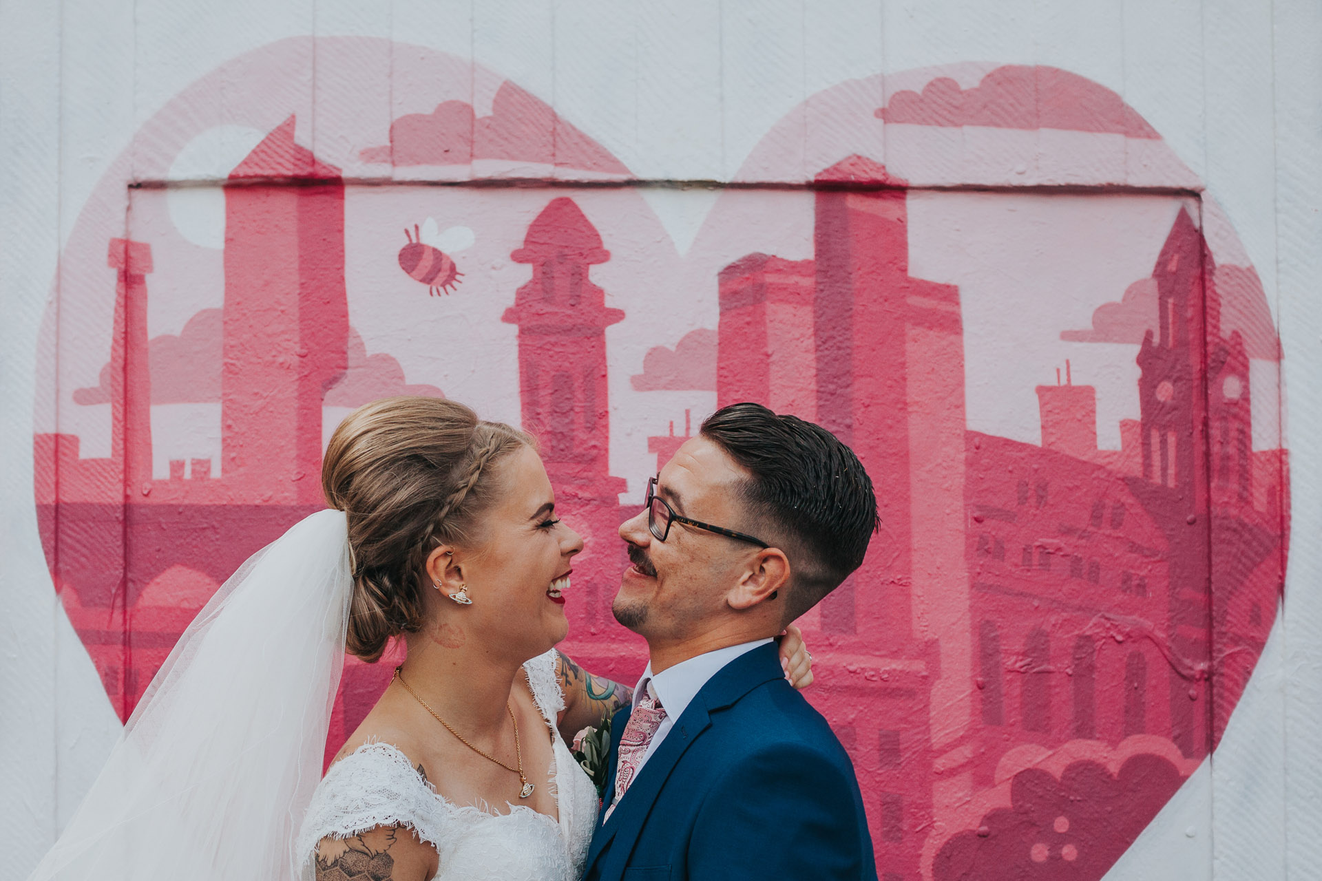 Cool bride and groom in front of Manchester graffiti. 