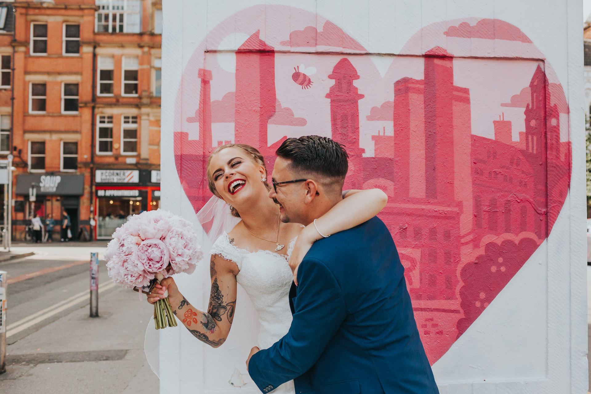 Bride and groom messing around on their wedding day in the Northern Quarter, Manchester. 