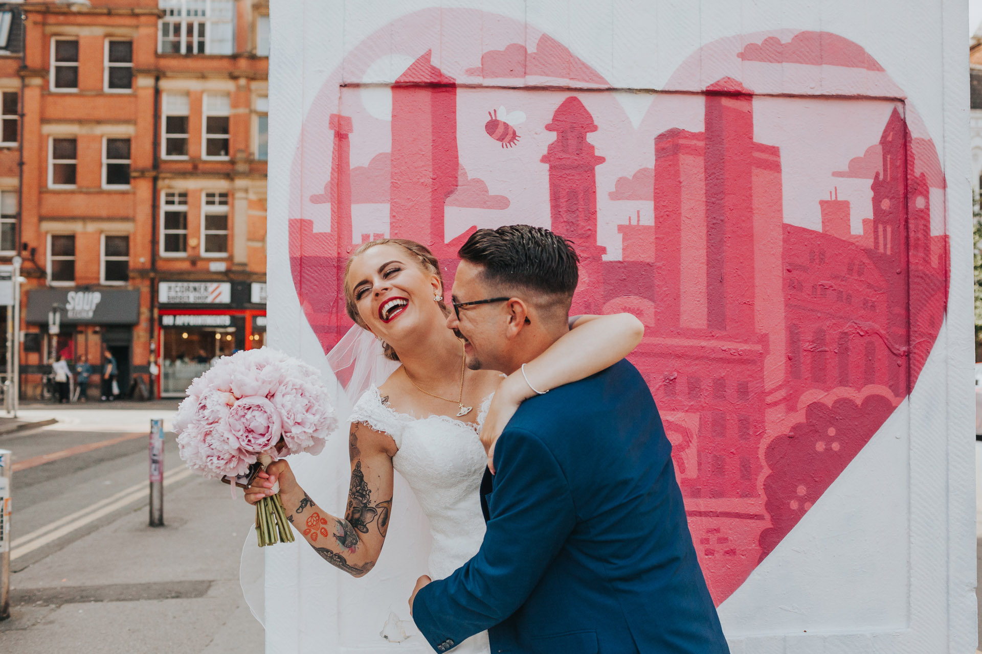 Bride and groom messing around on their wedding day in the Northern Quarter, Manchester.