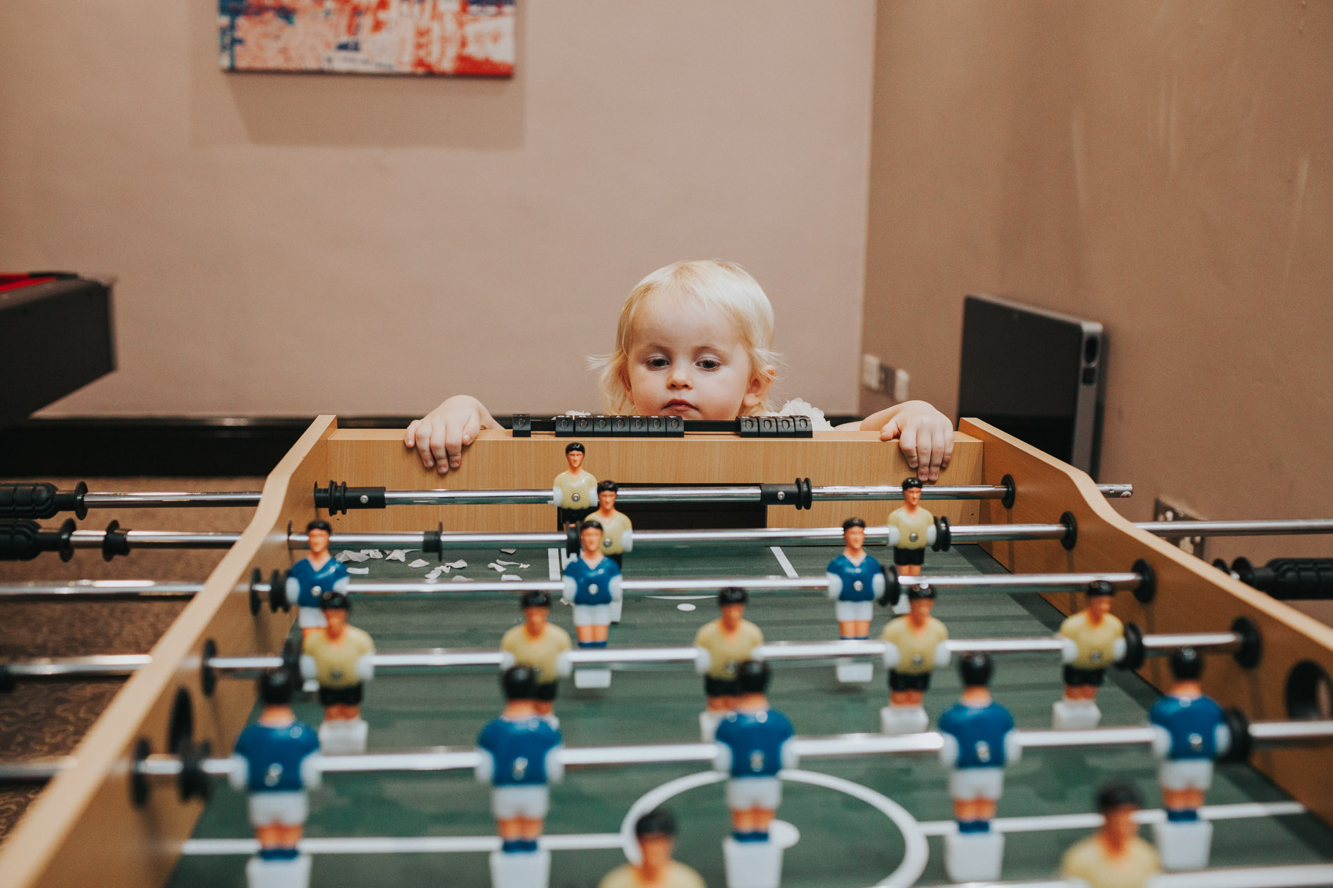 Toddler looking at table football.  