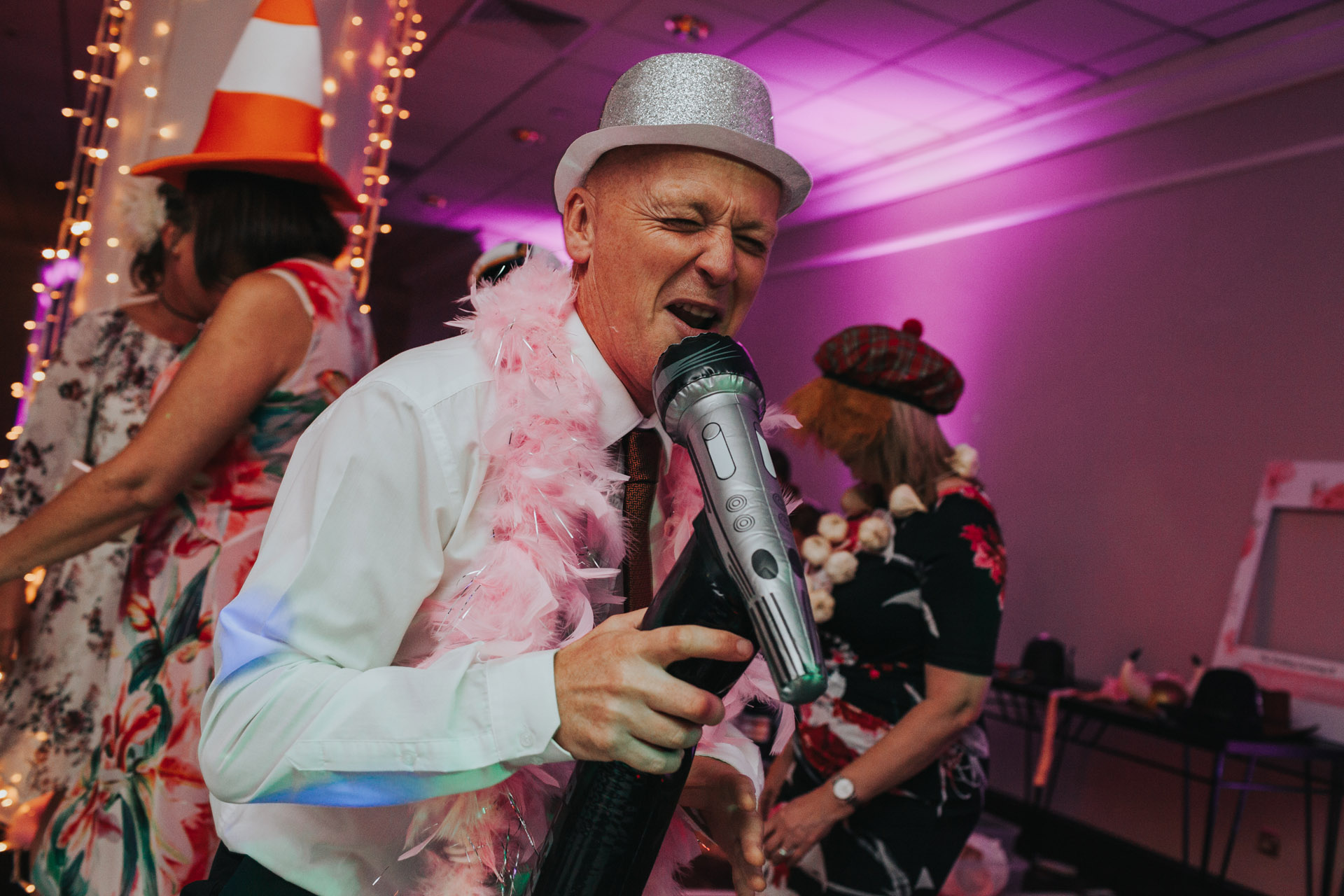 Man sings into blow up mic at wedding party.