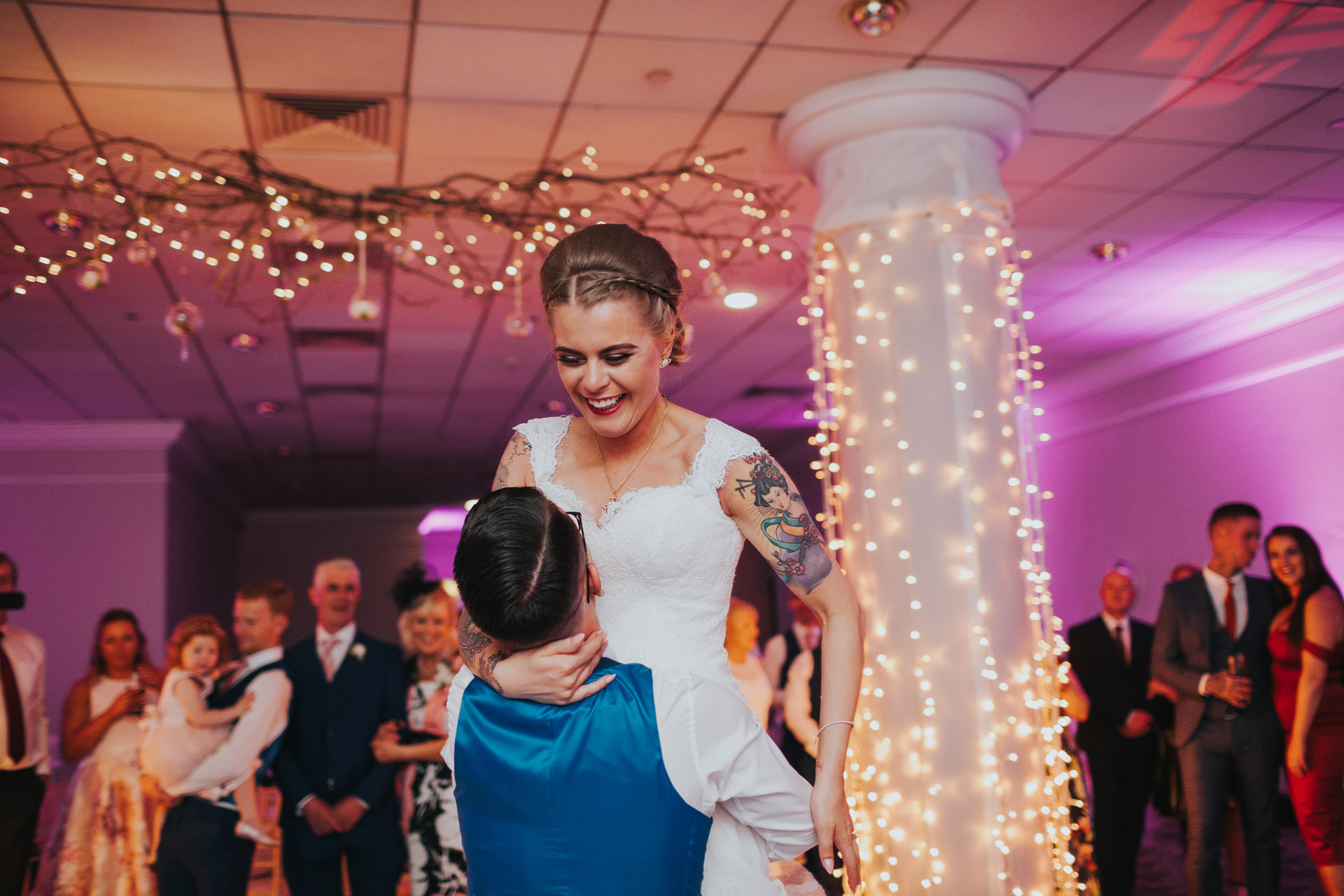 Groom lifts bride up on dance floor