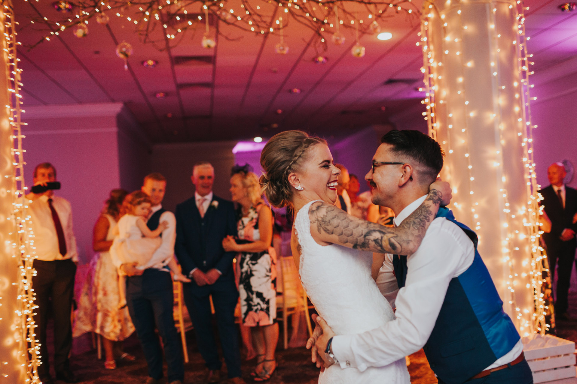 Bride and groom laugh together during first dance. 