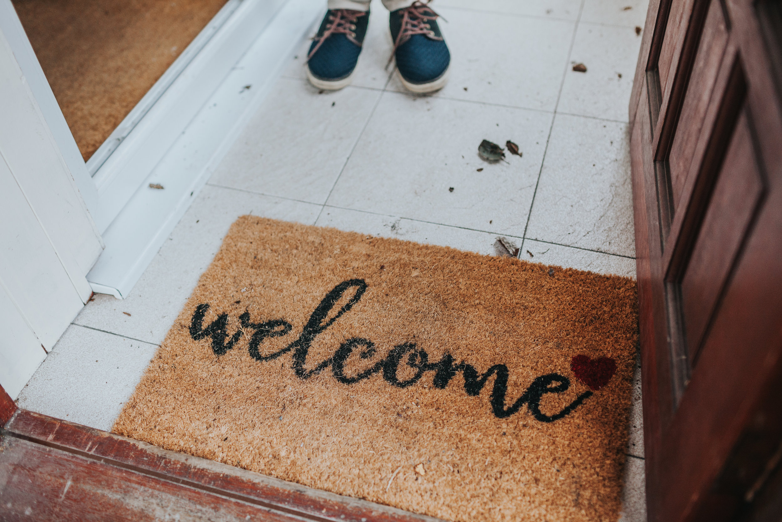 Welcome mat and feet at Evie's family home