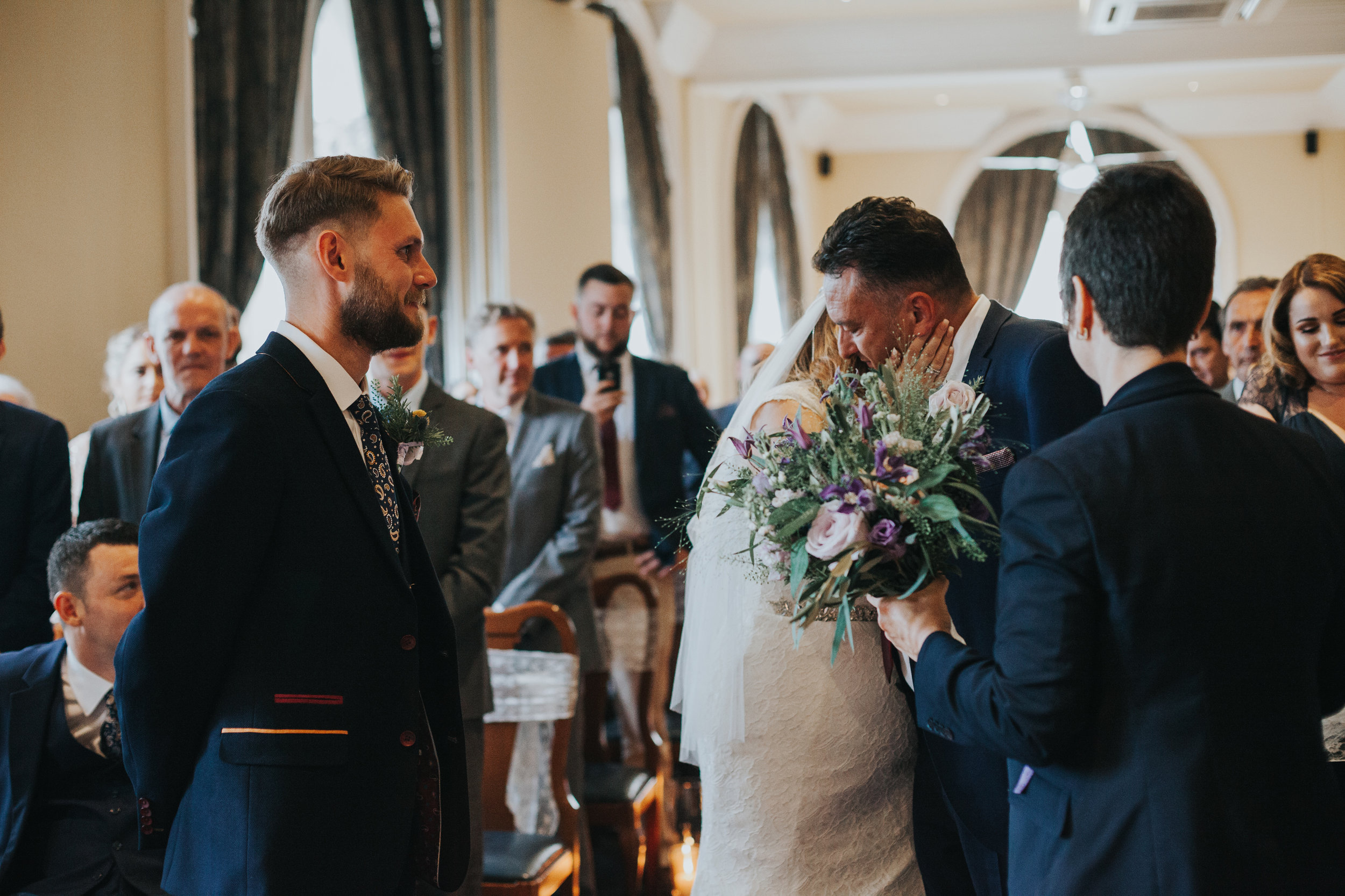 Father kisses bride at the end of the aisle. 