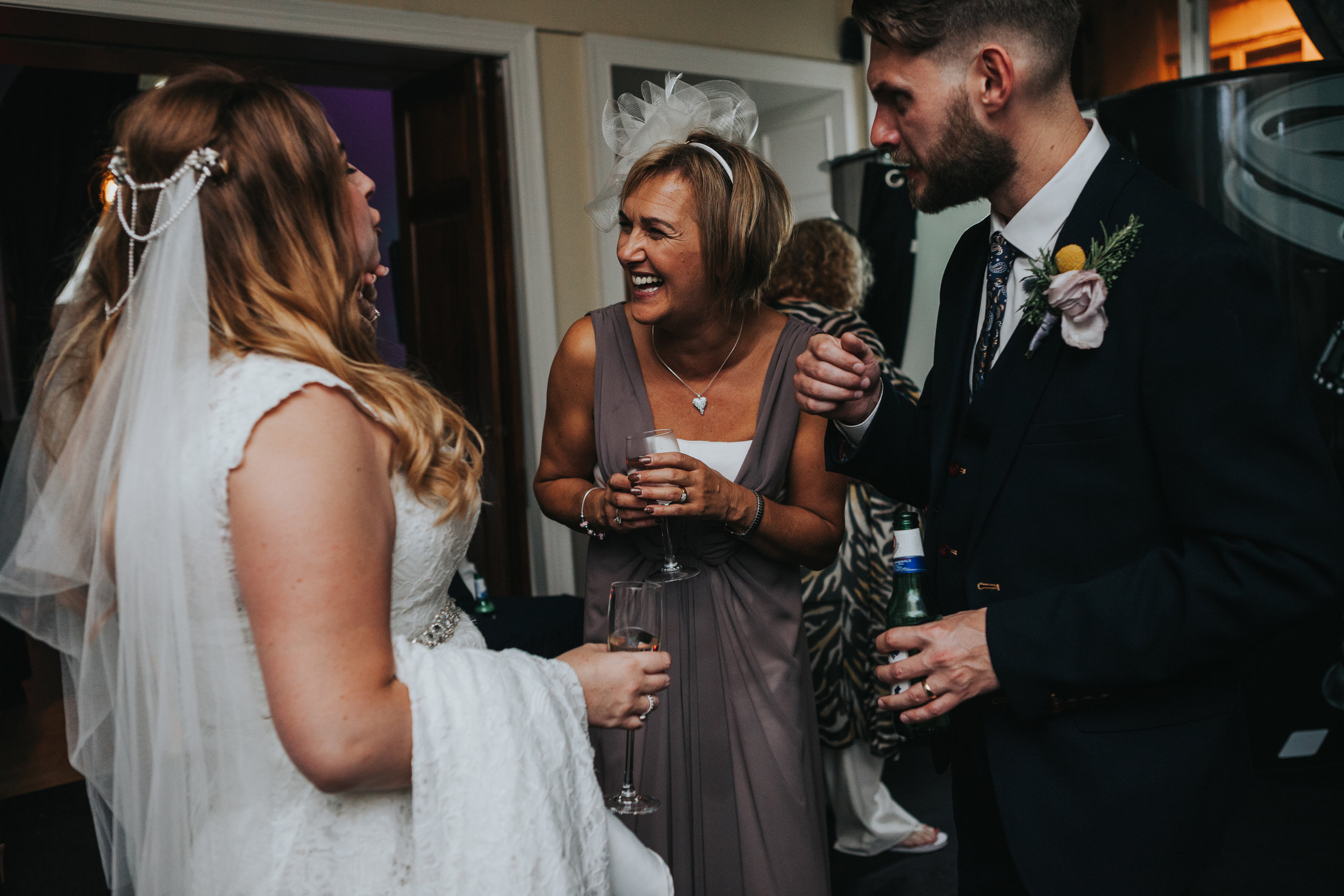 Bride laughs with Wedding Guest. 