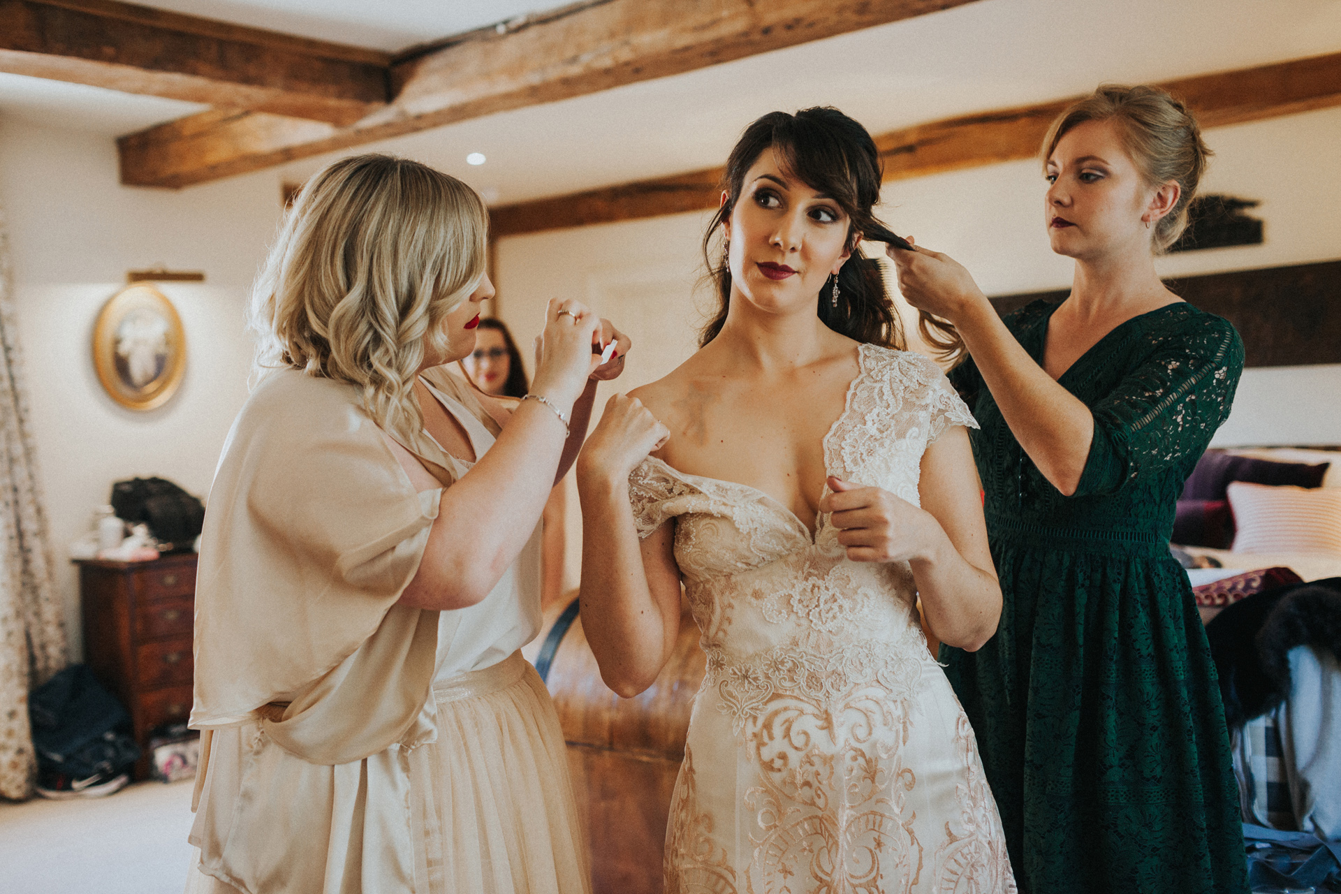 Bridesmaids fuss over Bride as she takes in the moment. 