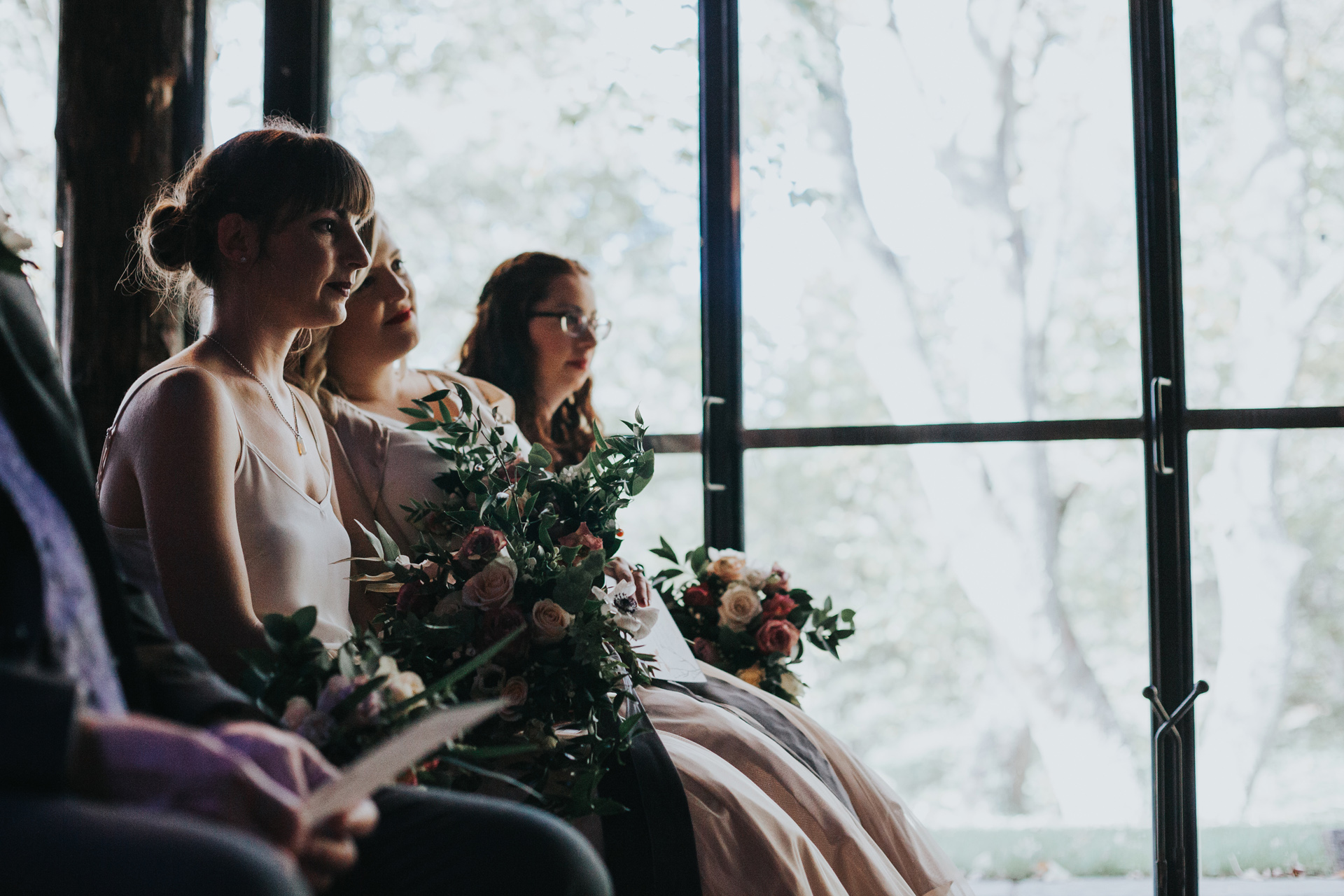 Bridesmaid sits in the shadows. 