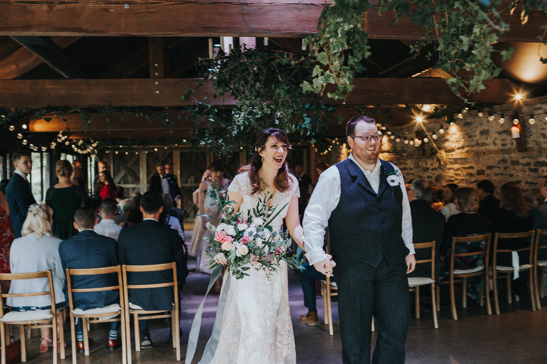 Bride and Groom exit the aisle at Dewsall Court 