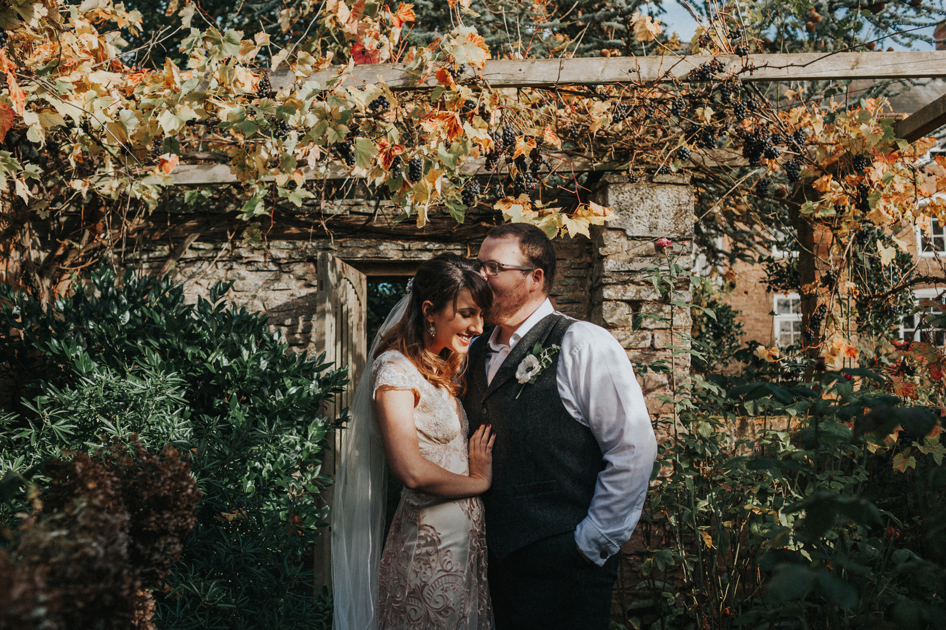 The couple smile together in the sunlight. 