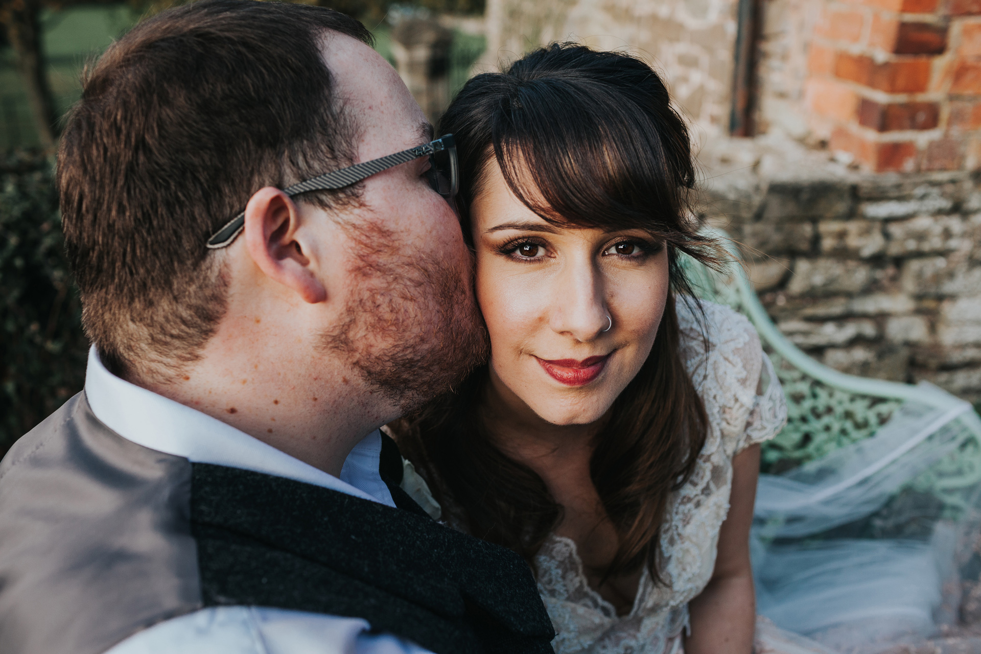 Groom gives bride a kiss. 