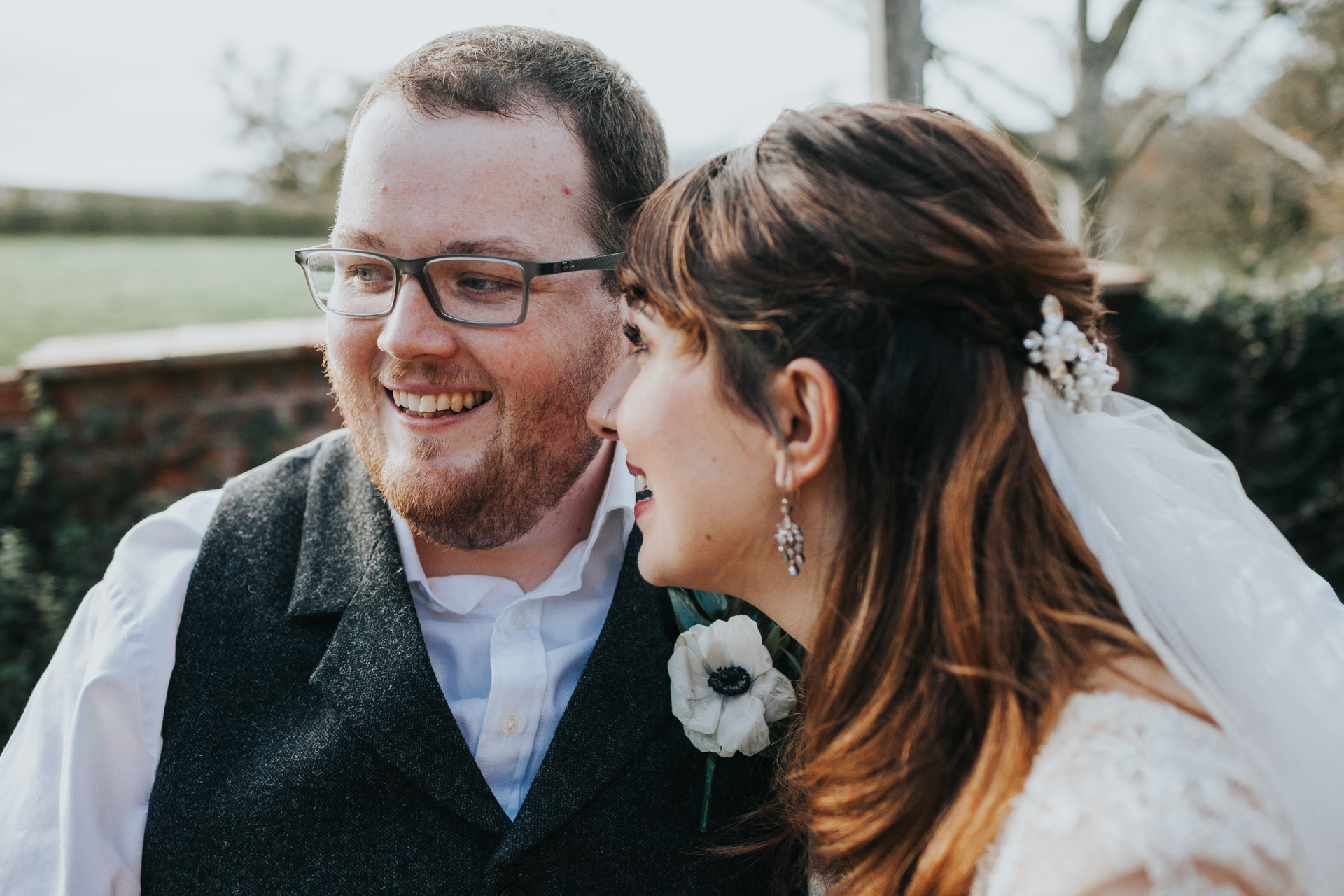 Groom and bride smile together.
