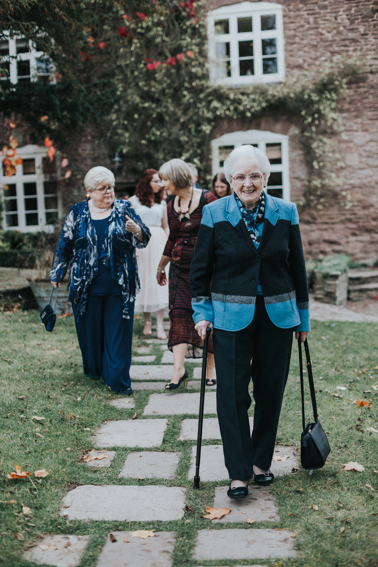 Wedding guests walking on path towards ceremony room.