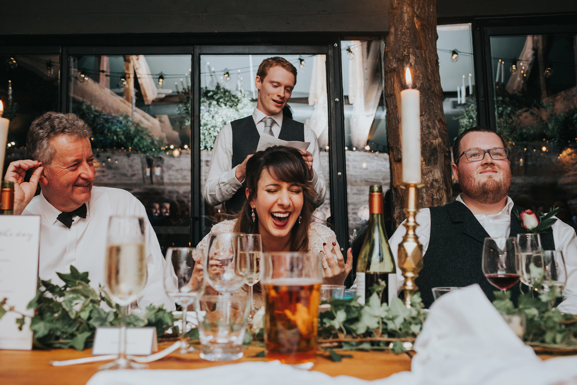 Bride and groom laughing at best mans speech. 